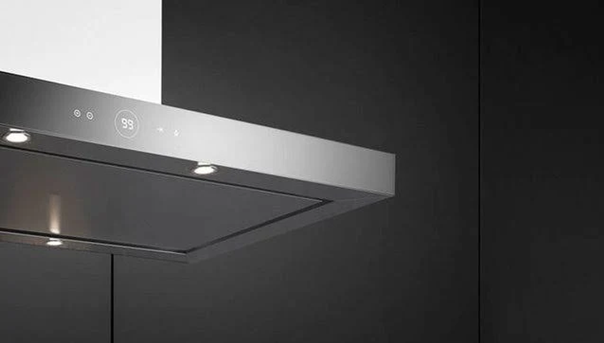 Primo piano di una moderna cappa in acciaio inossidabile con luci, su sfondo grigio scuro.