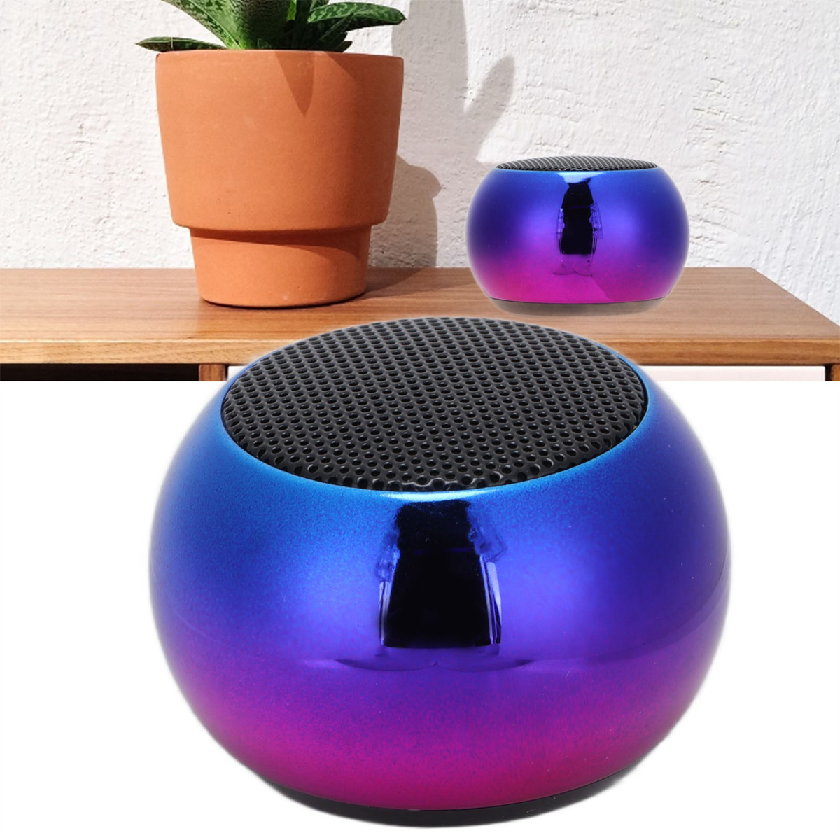 Blau-violetter Lautsprecher mit schwarzem Gitter, und ein kleinerer auf einem Holzregal.