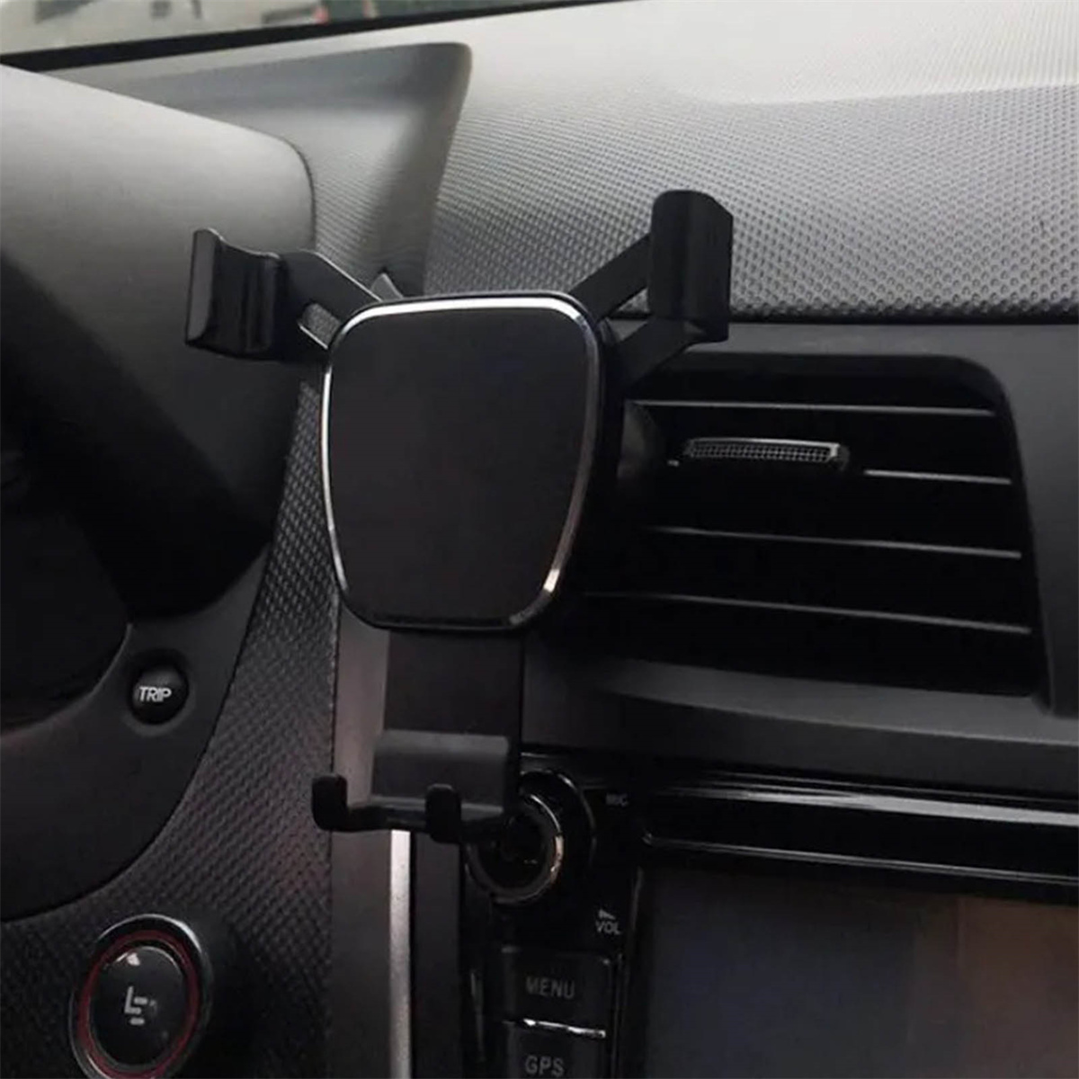 Schwarze Autotelefonhalterung auf einem Armaturenbrett mit grauem Innenraum montiert.