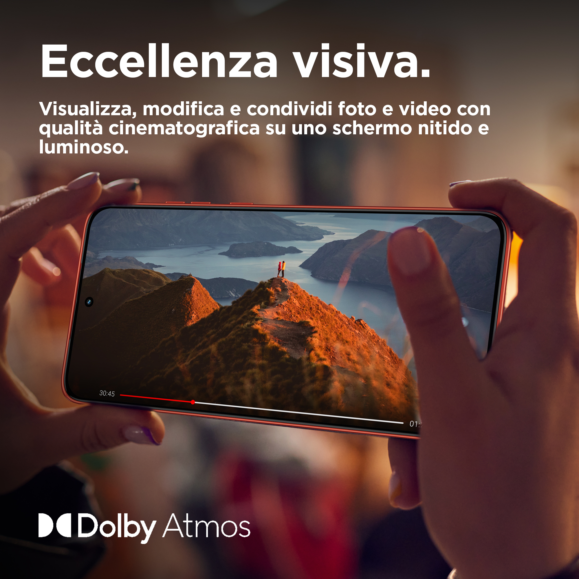 Dłonie trzymające czerwony telefon, wyświetlający wideo z gór.