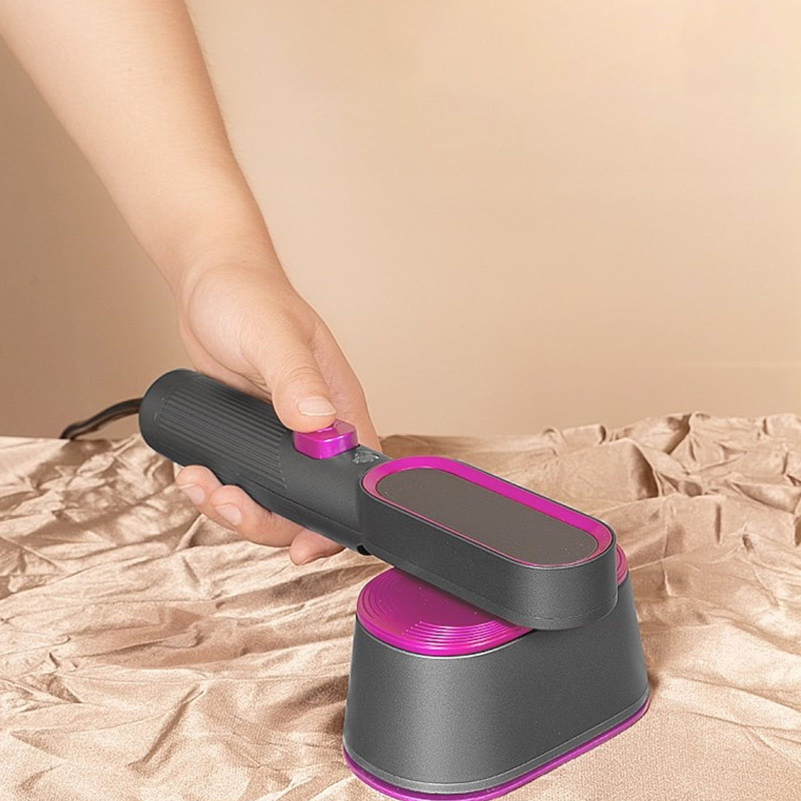 Eine Hand hält einen schwarz-violetten Hand-Dampfgarer über zerknittertem braunem Papier.