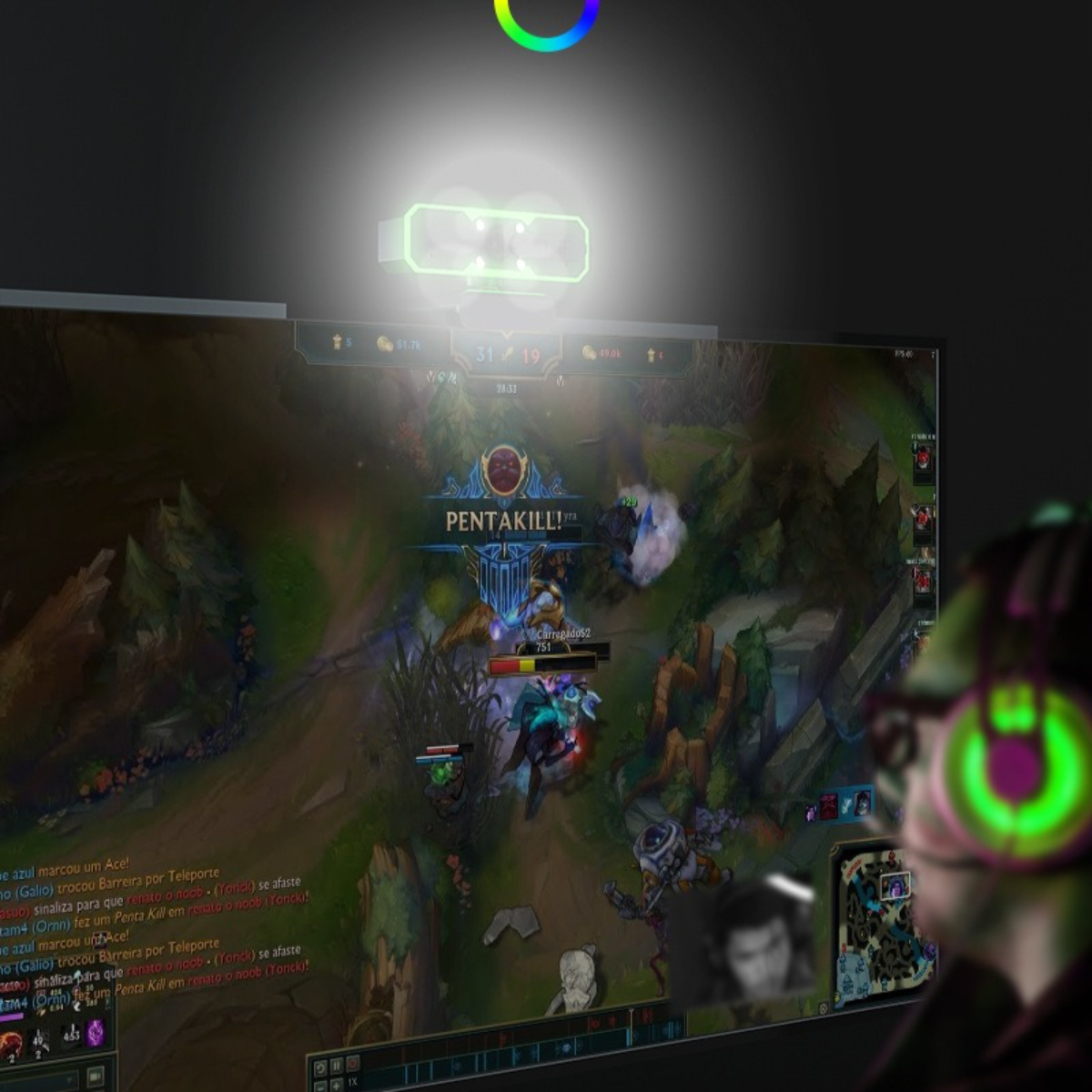 Eine Person mit Kopfhörern schaut sich ein Spiel auf einem Monitor an. Ein Licht befindet sich oben auf dem Bildschirm. Spielszene sichtbar.