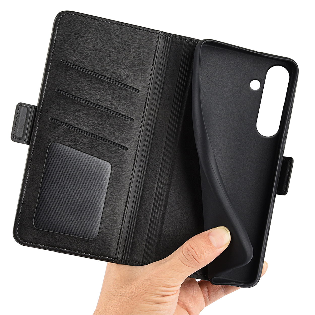Main tenant un étui portefeuille noir ouvert, révélant des fentes pour cartes et un support pour téléphone.