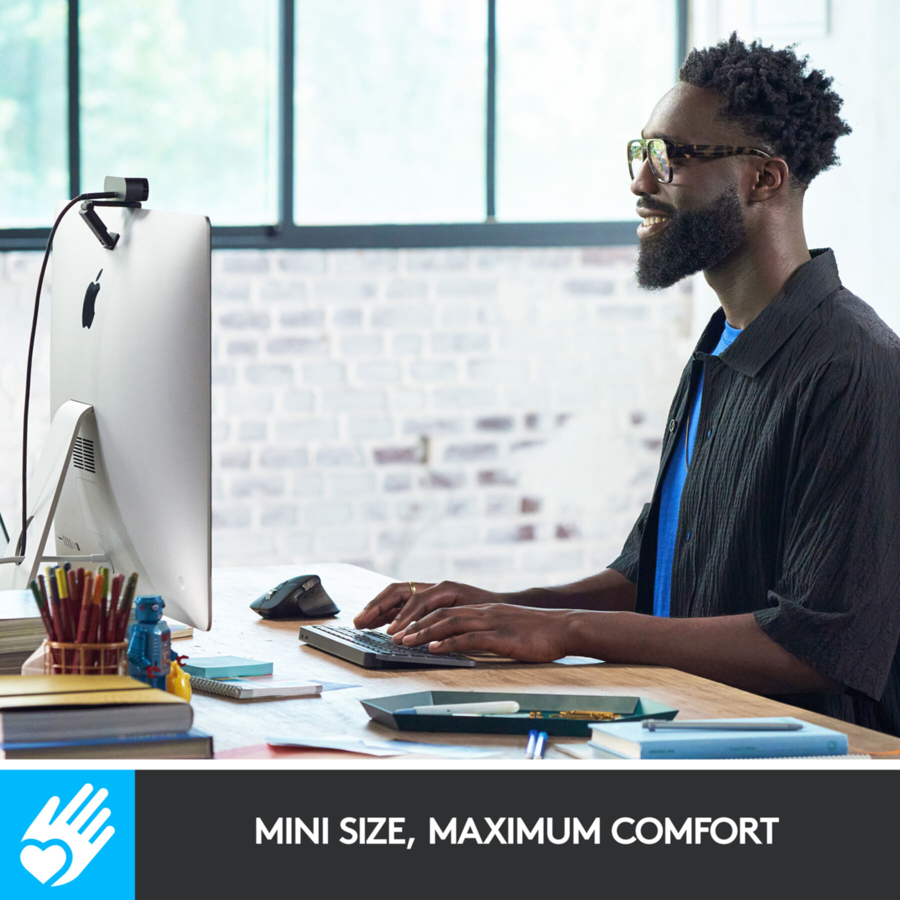 Mężczyzna korzysta z komputera. Tekst brzmi: Mini rozmiar, maksymalny komfort.