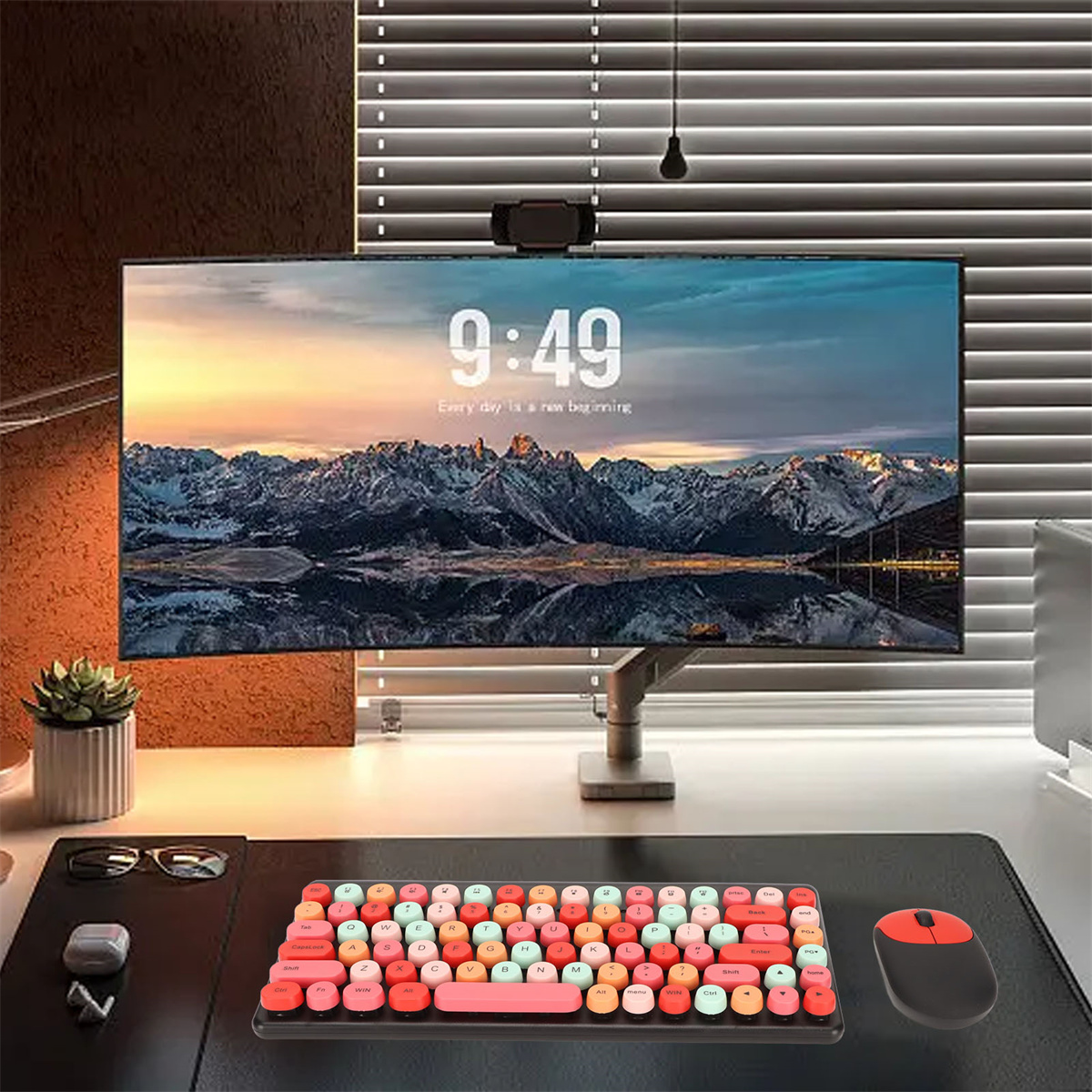 Ein Schreibtisch-Setup mit einem Monitor, der eine Uhr, eine Tastatur, eine Maus und eine kleine Pflanze anzeigt.