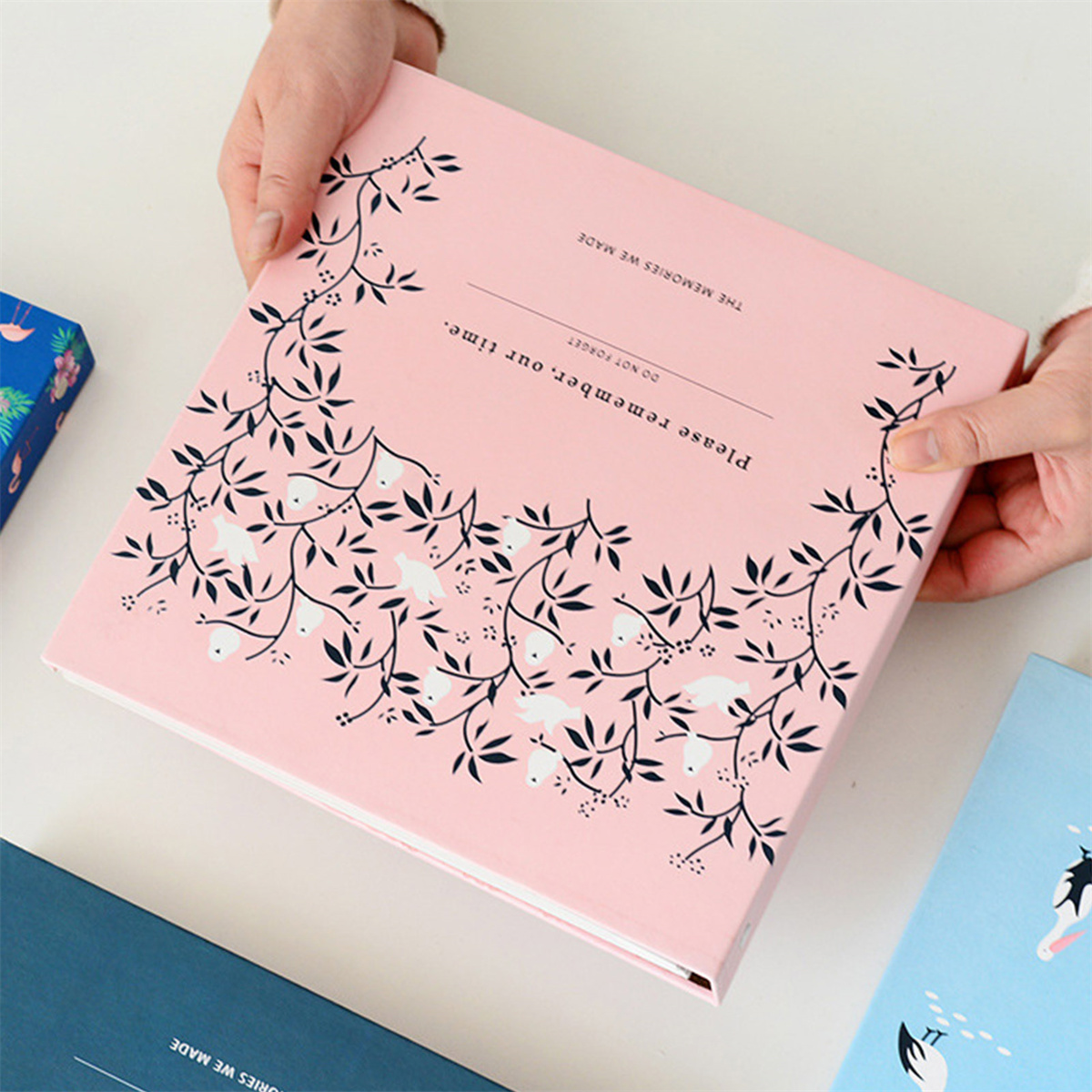 Ein rosa Fotoalbum mit floralen Designs und dem Text 'Please remember our time'.