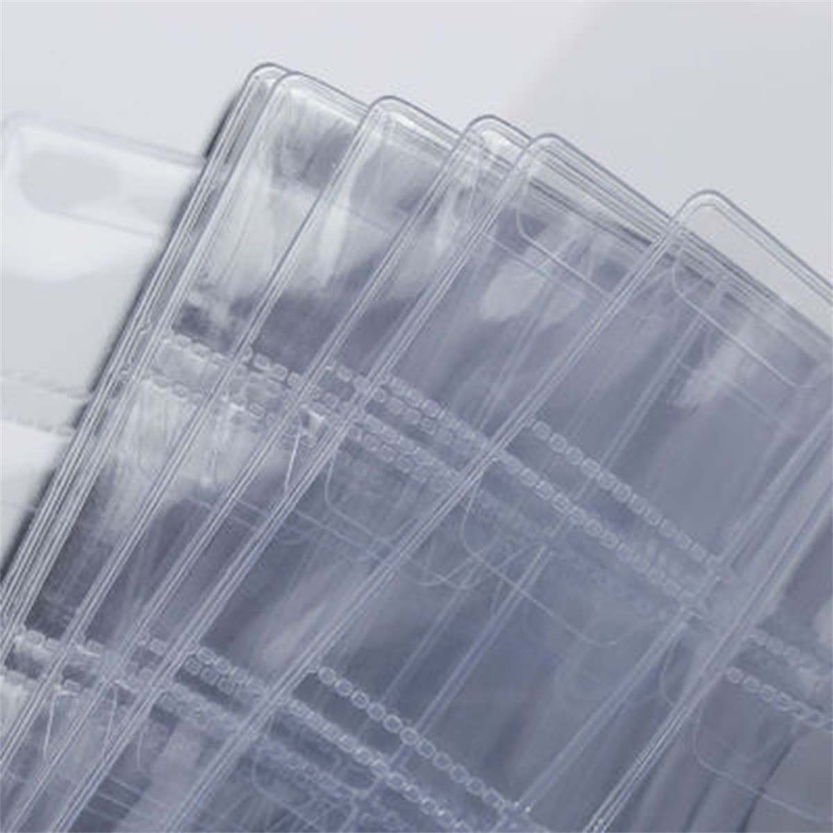 Stapel klarer Plastikkartenhalter. Sie sind transparent und leicht abgewinkelt, zeigen Schichten.