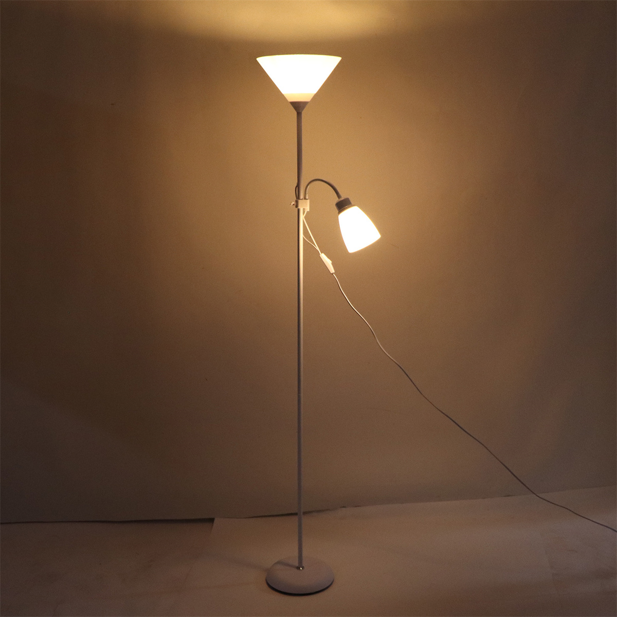 Eine hohe Stehlampe mit einem weißen, konischen Schirm und einem kleineren Leselicht. Der Hintergrund ist braun.