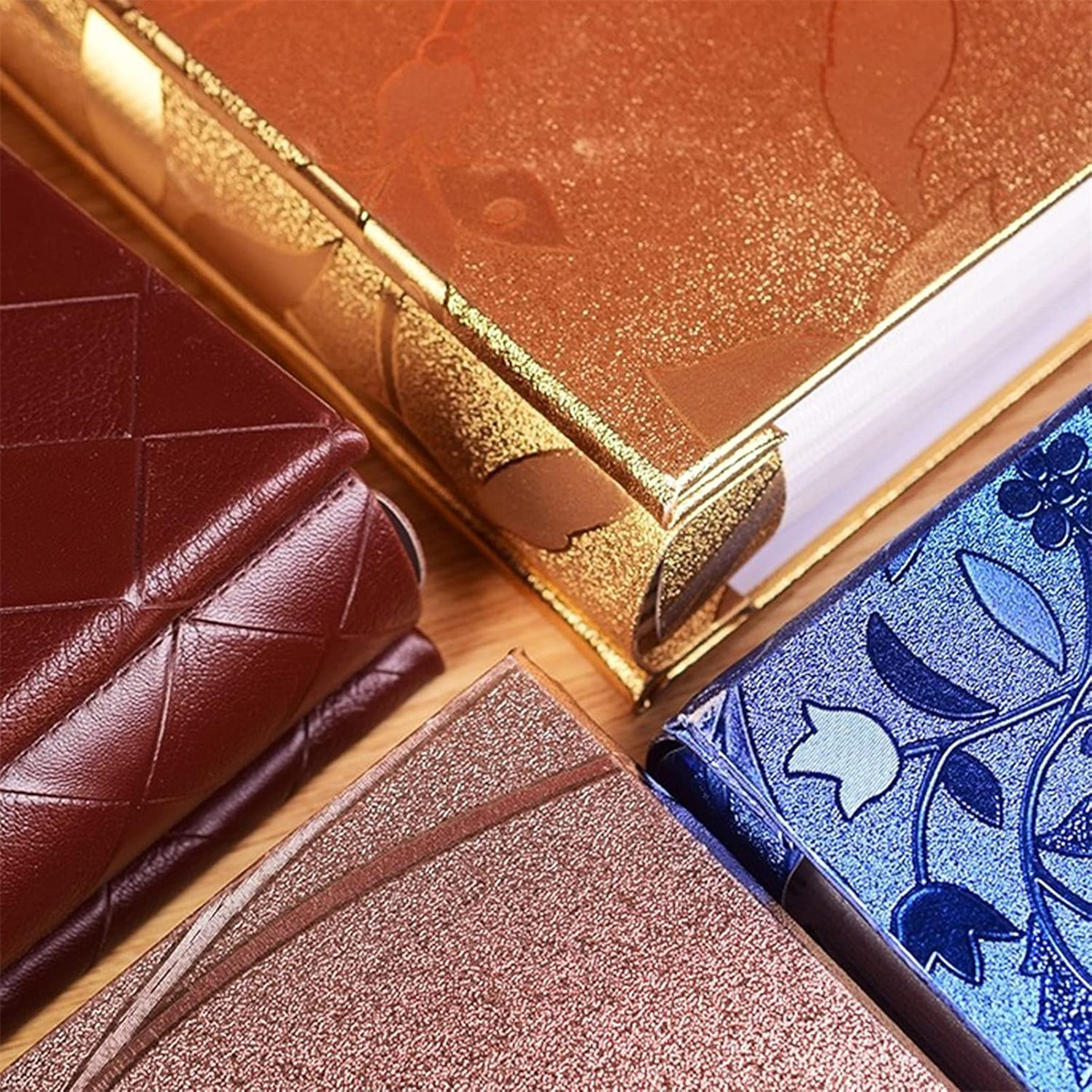 Nahaufnahme von Büchern mit goldenen, braunen und blauen Einbänden mit verzierten Designs.