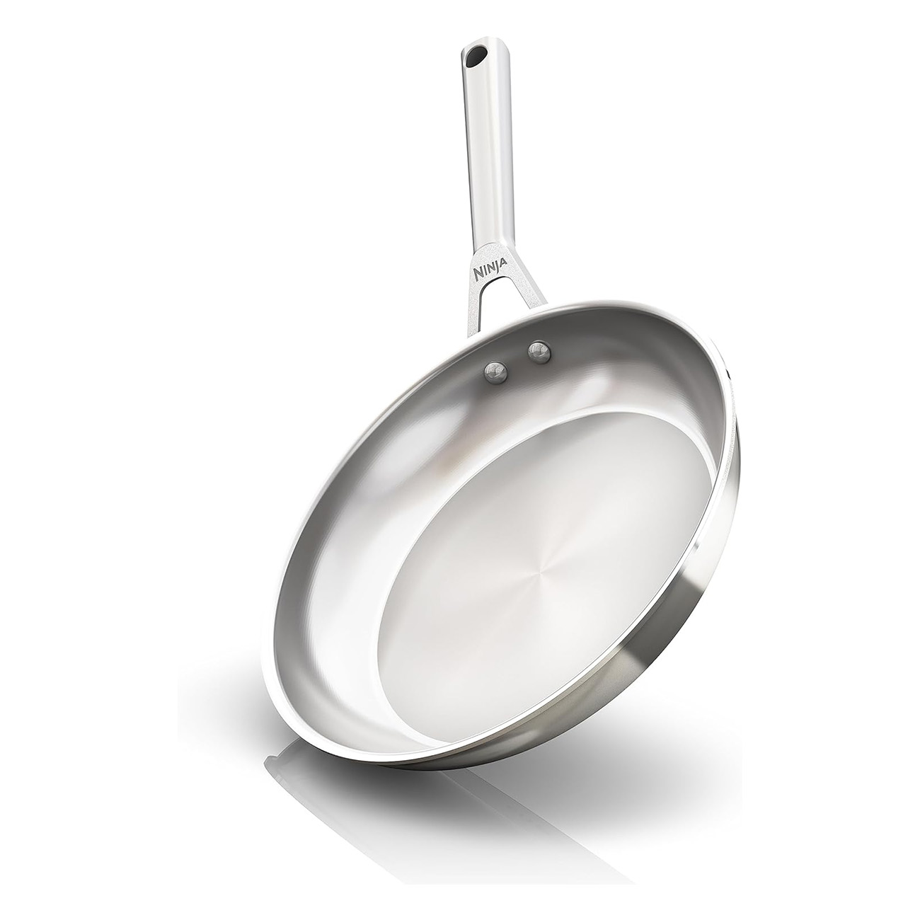 Błyszcząca srebrna patelnia z długim uchwytem, ustawiona pod kątem na białym tle.