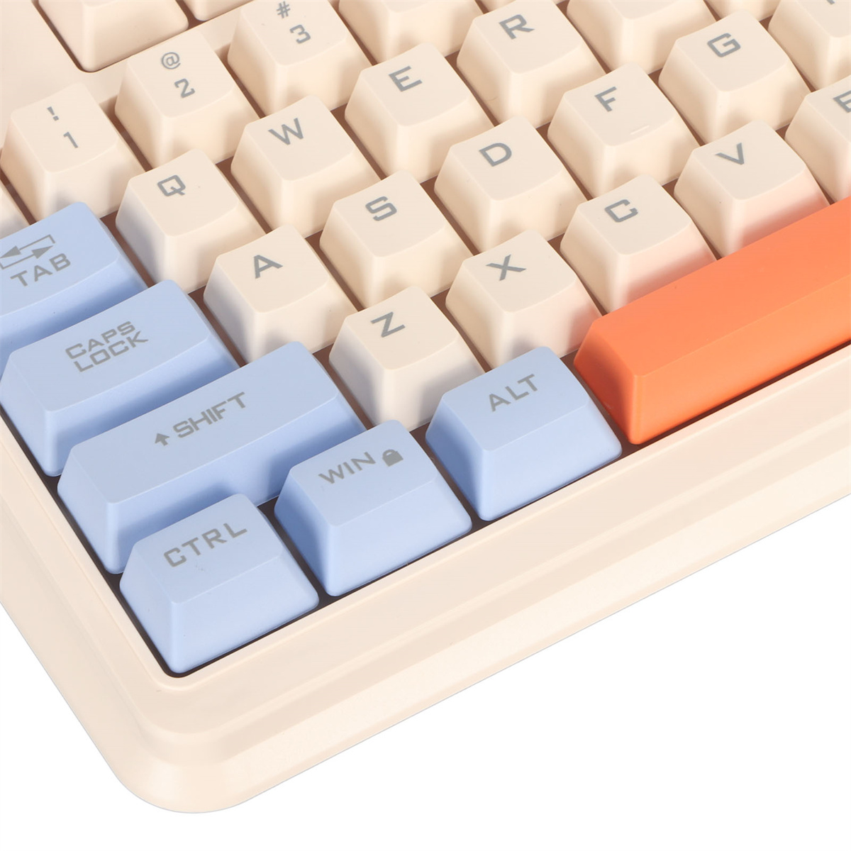 Nahaufnahme einer Tastatur mit cremefarbenen und blauen Tasten. Die Leertaste ist orange.