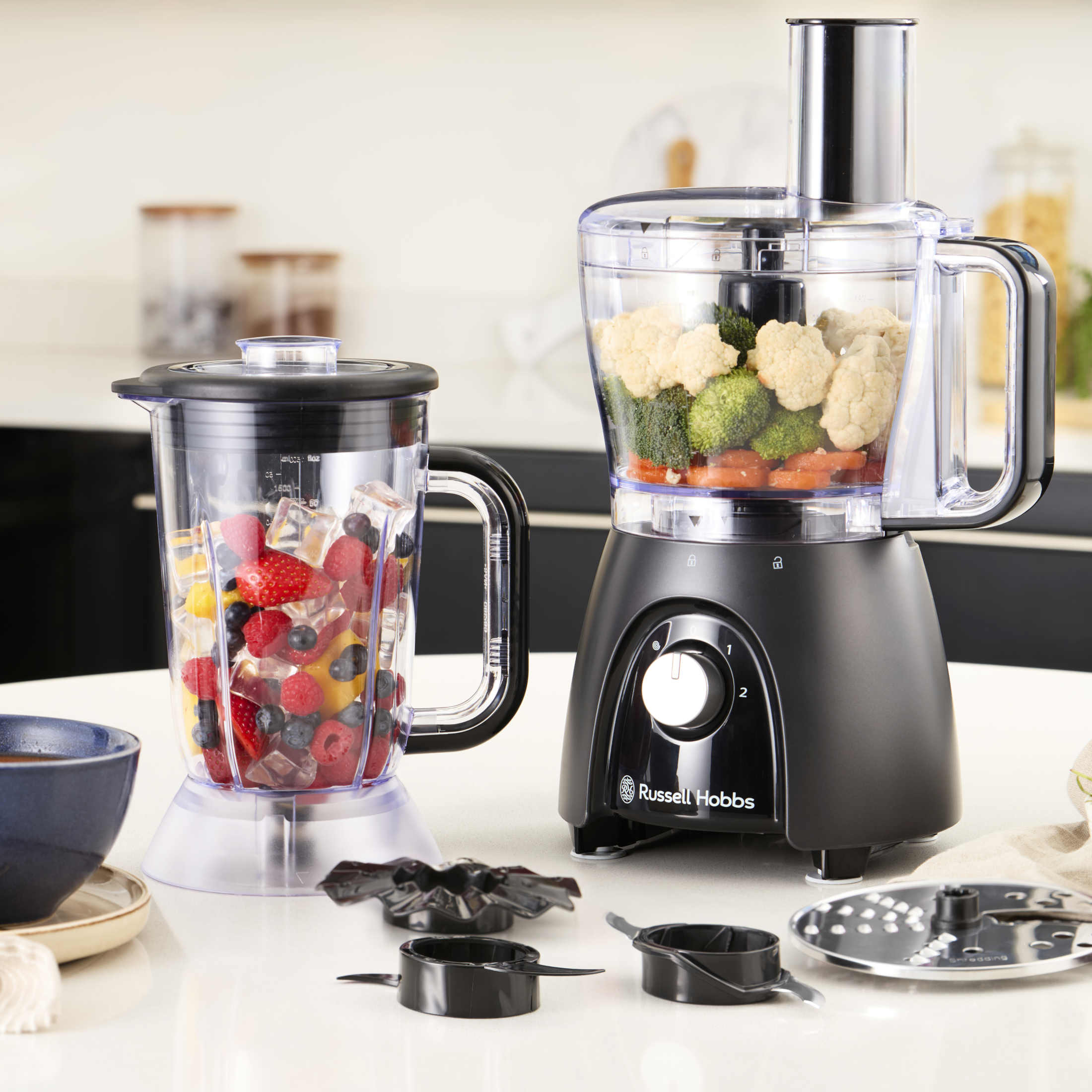 Küchenmaschine mit Mixer und Schüssel. Zutaten: Früchte, Gemüse und Eis.