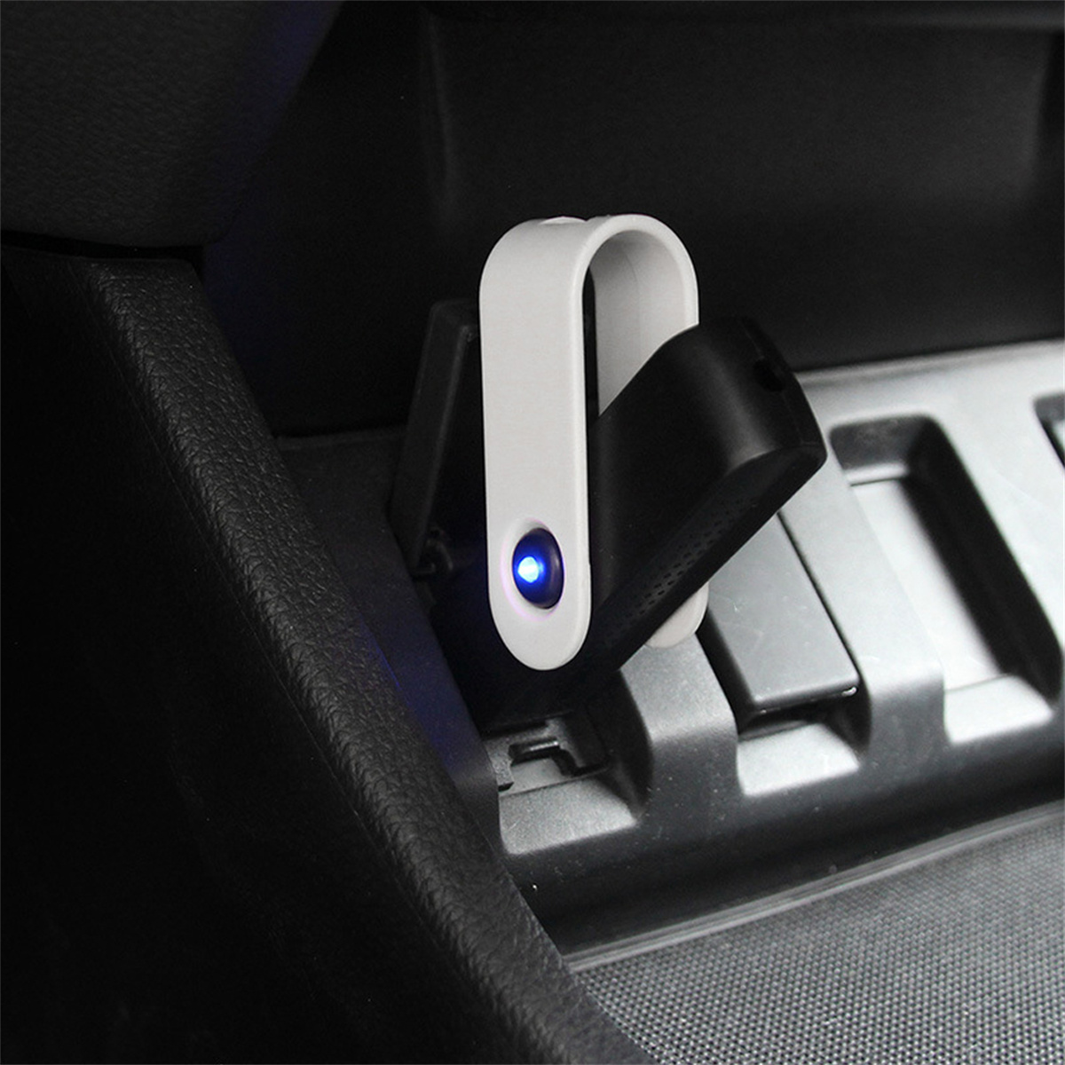 Ein weißes und schwarzes USB-Autoladegerät mit blauem Licht. Es ist in der Mittelkonsole des Autos eingesetzt.