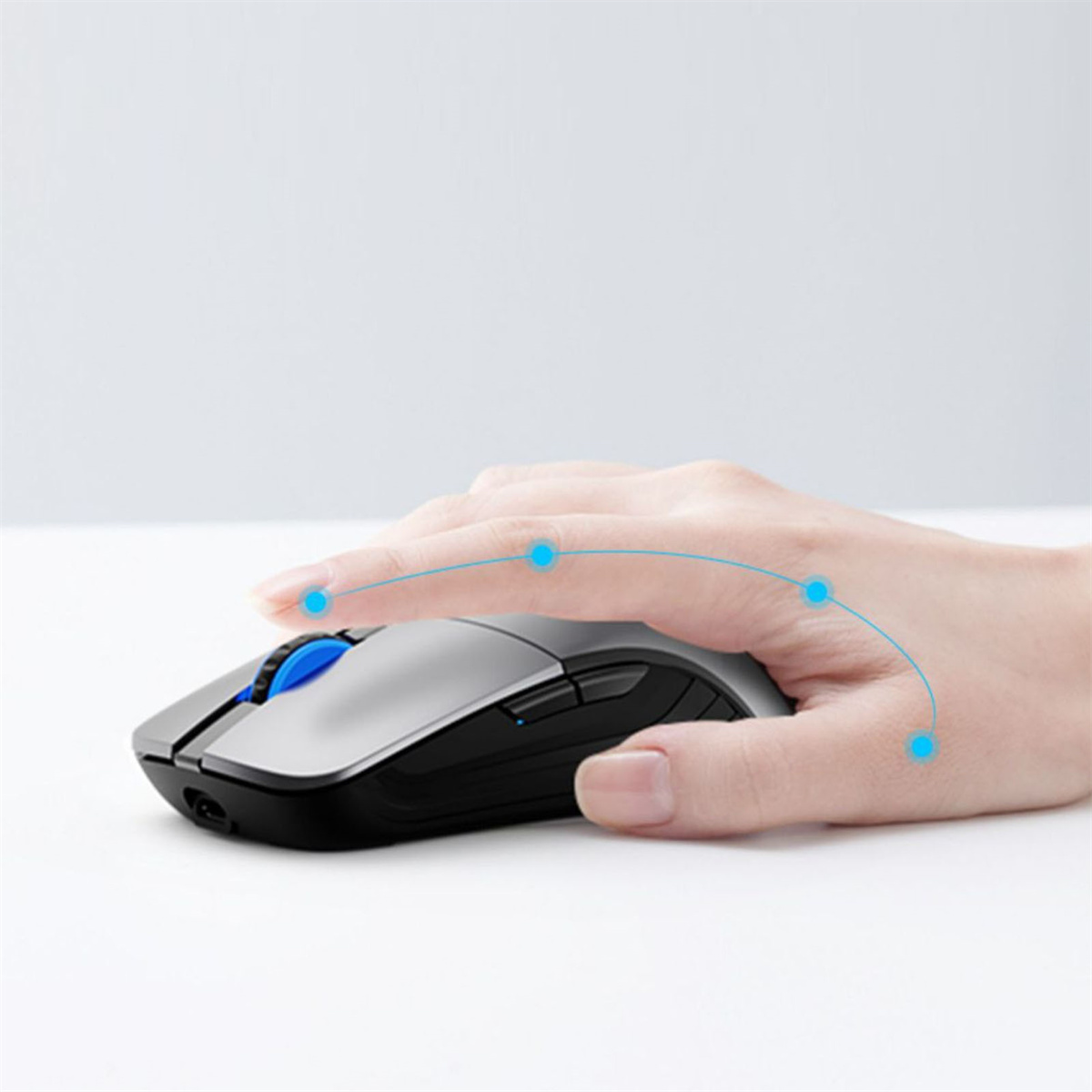 Eine Hand, die eine grau-schwarze Computermaus hält. Die Maus hat ein blaues Scrollrad.