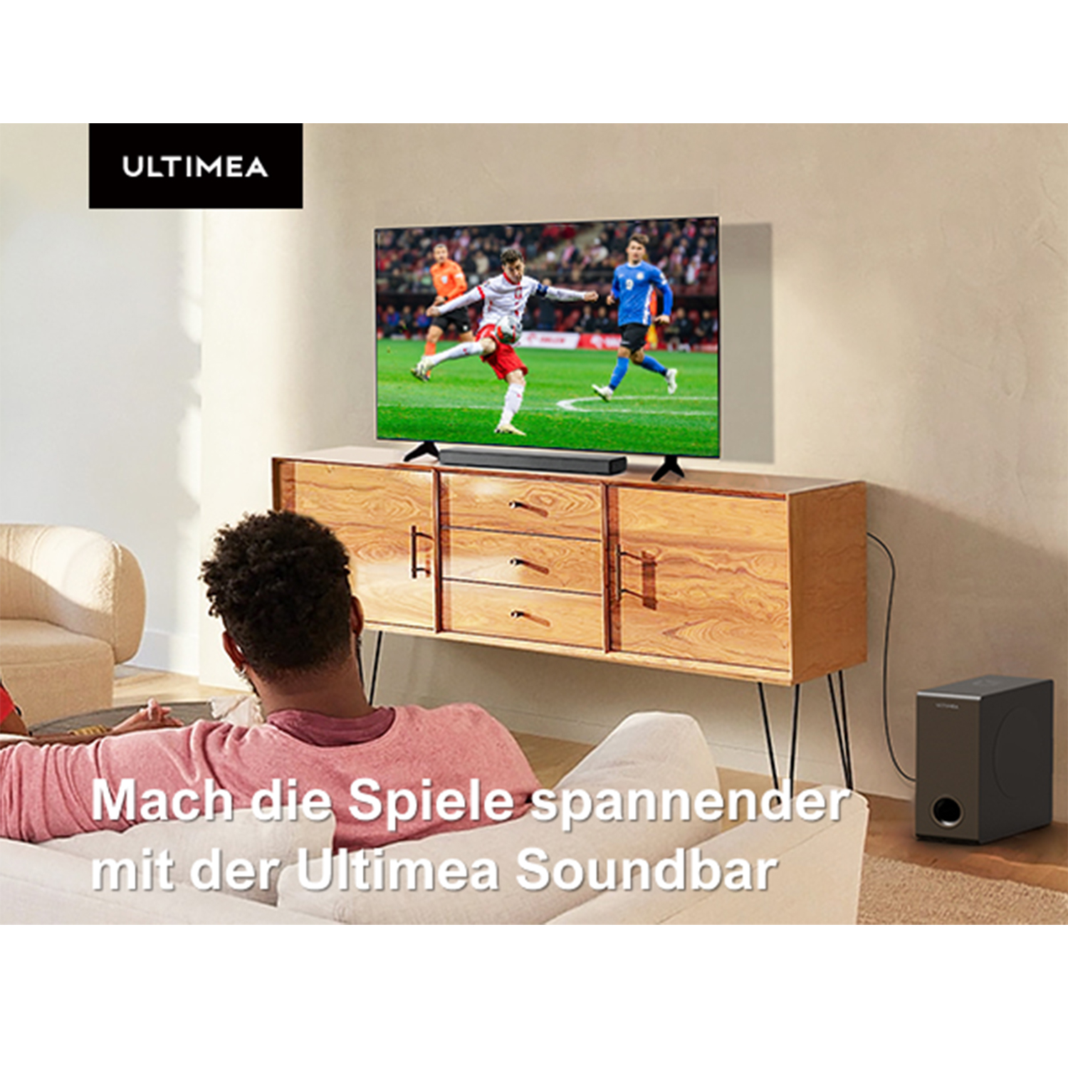 Ein Mann sieht ein Fußballspiel auf einem Fernseher mit Soundbar. Der Fernseher zeigt das Ultimea-Logo.