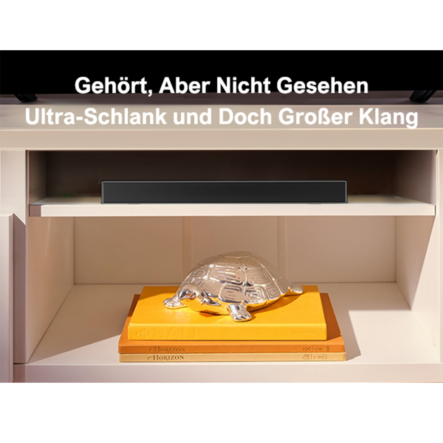 Weißer Schrank mit Regalen. Eine schwarze Soundbar auf dem oberen Regal. Eine silberne Schildkröte und Bücher.