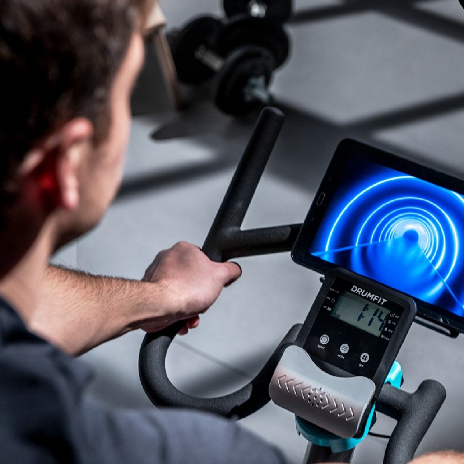 Una persona su una cyclette che guarda un tablet.