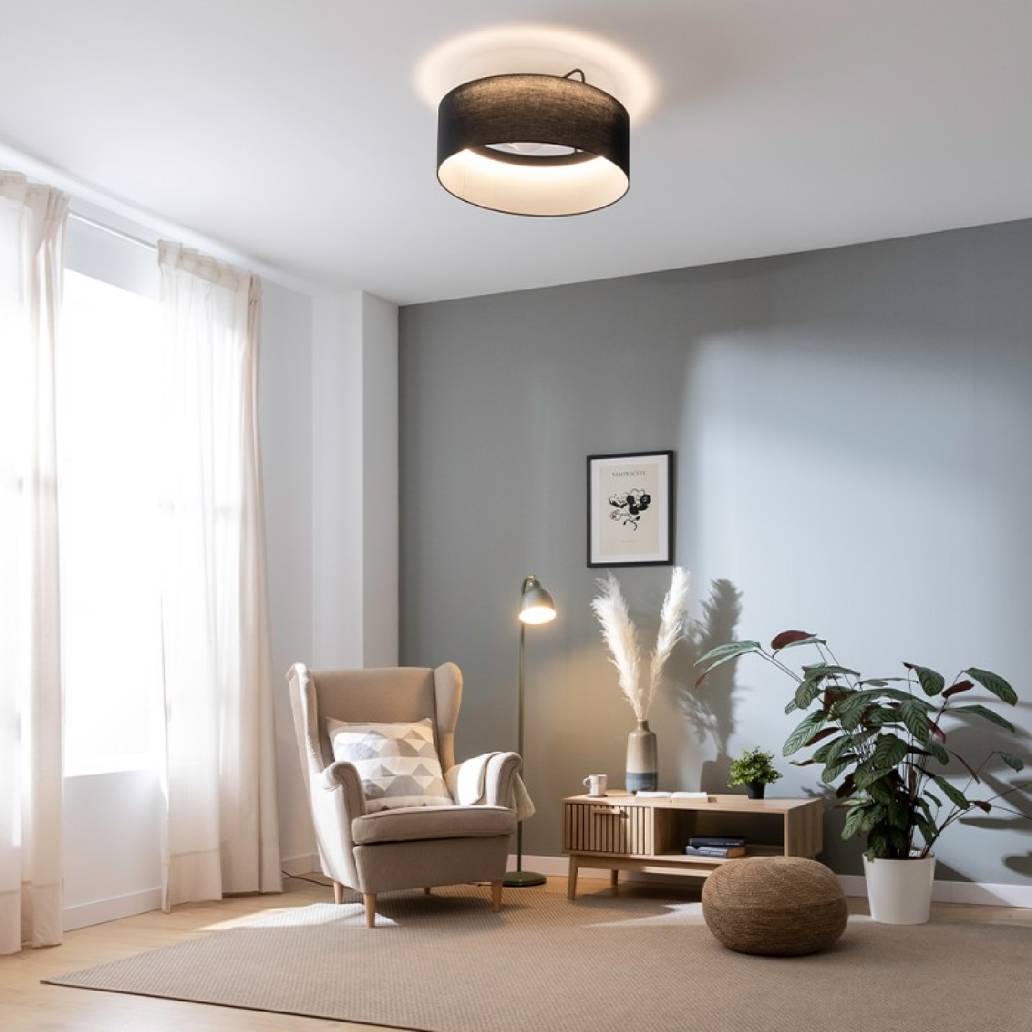 Salón con lámpara de techo, sillón y mesa auxiliar con decoración.