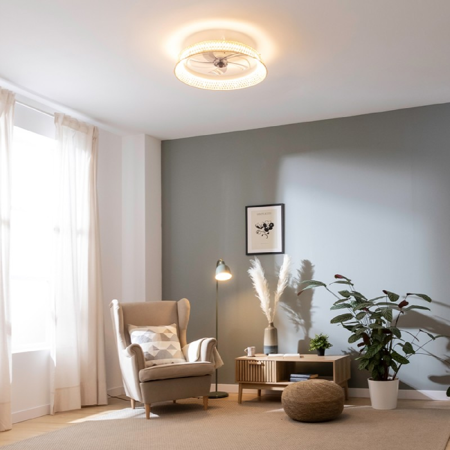 Una sala de estar con ventilador de techo. Incluye una silla, decoración y obras de arte en una pared gris.