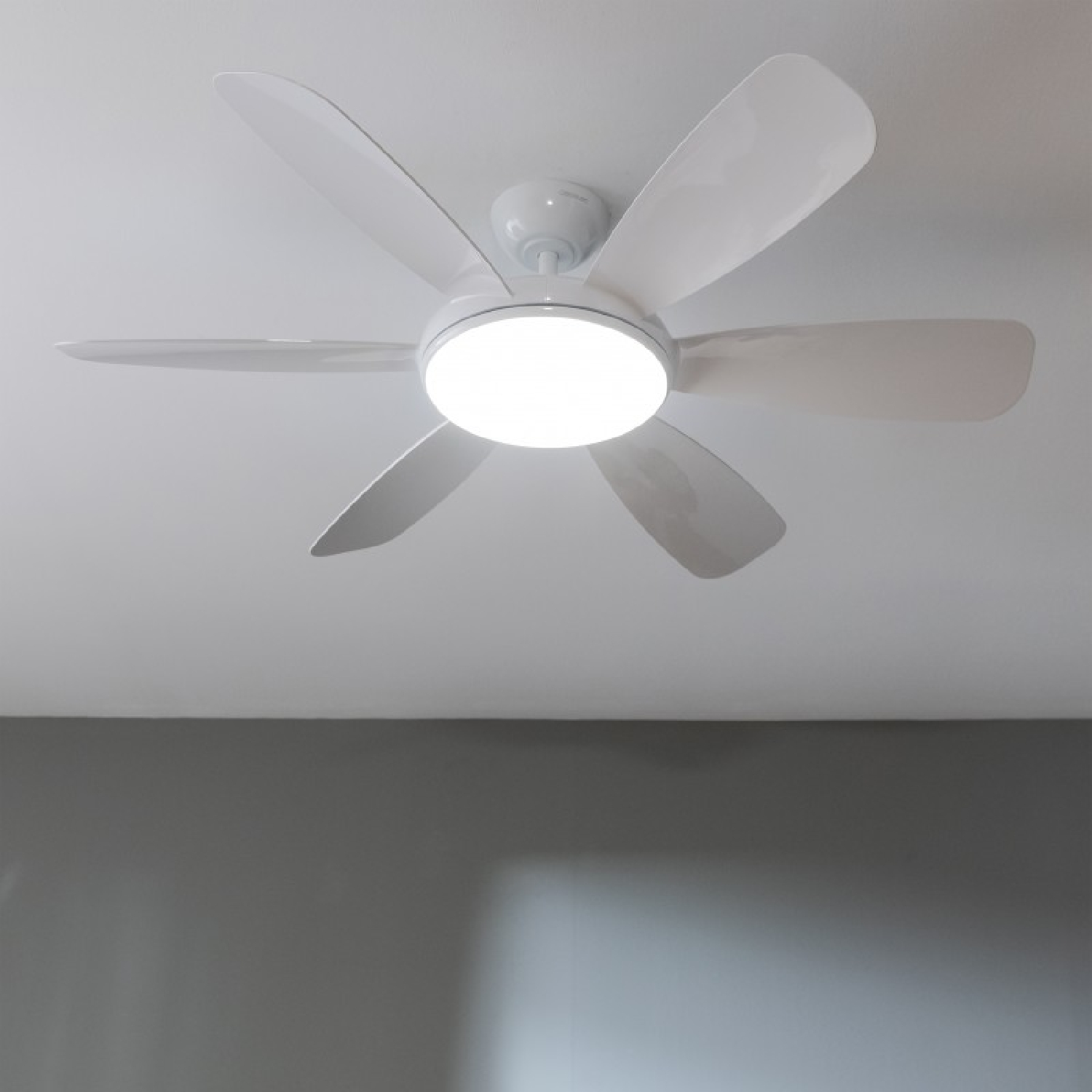 Un ventilador de techo blanco con luces, montado en un techo blanco.