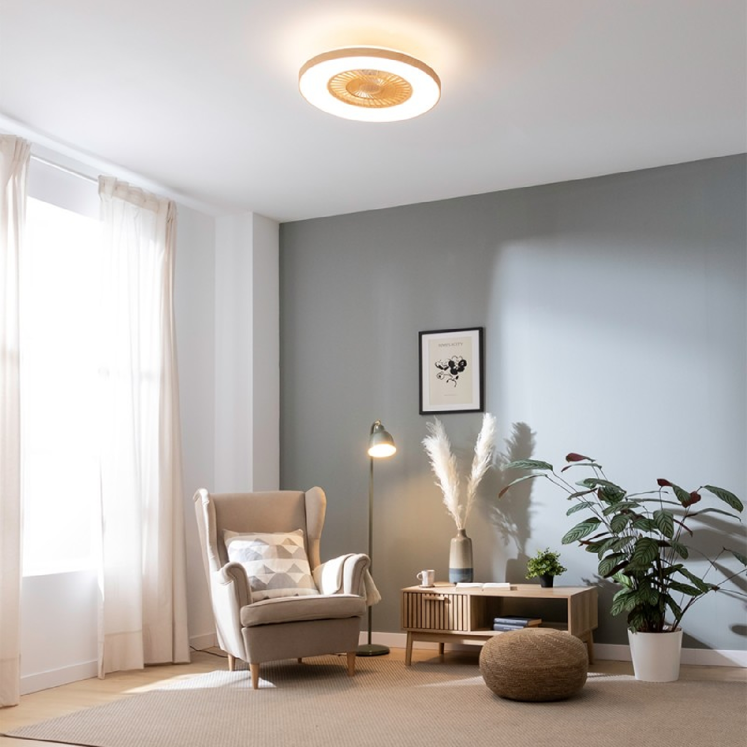 Salón con ventilador de techo, sillón y obras de arte. Colores neutros crean ambiente acogedor.