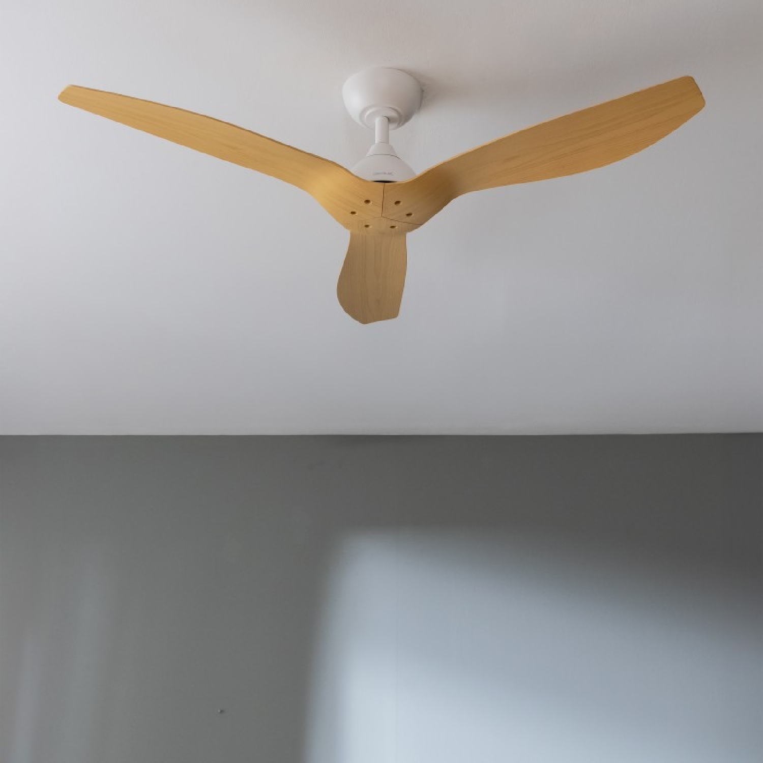 Ventilatore da soffitto con pale in legno chiaro e alloggiamento motore bianco.