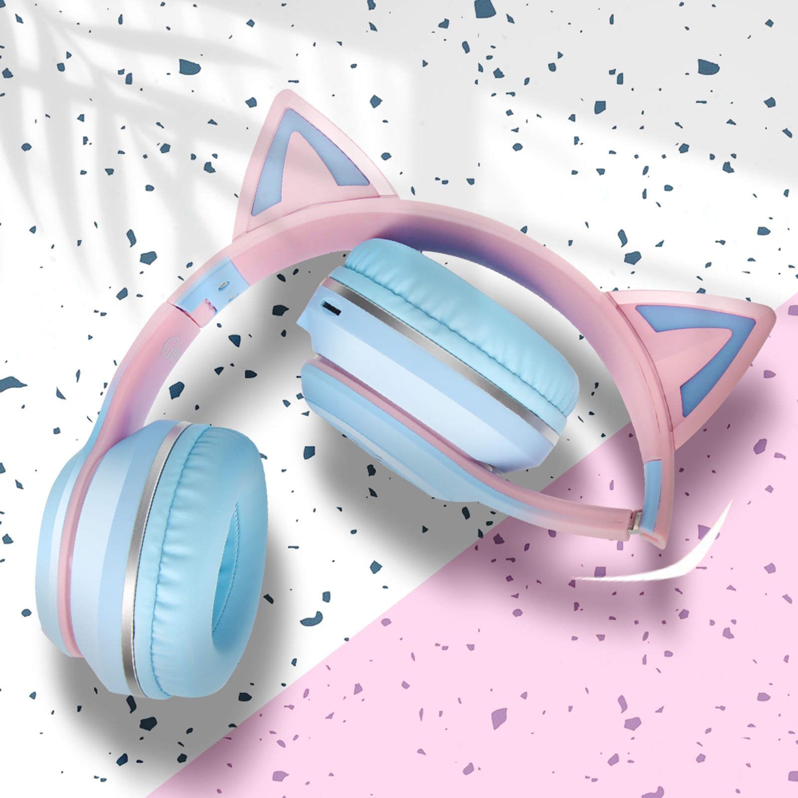 Rosa und blaue Katzenohr-Kopfhörer auf weißem und rosa gepunkteten Hintergrund.