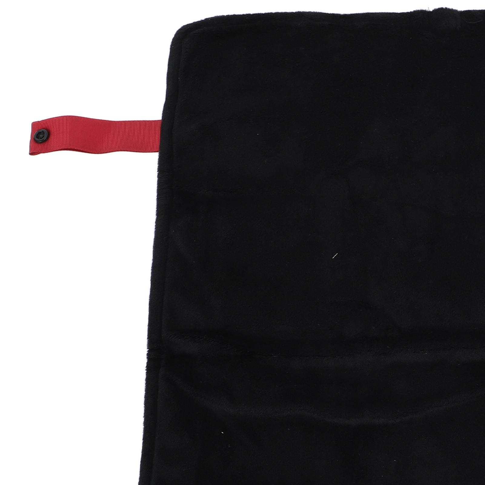 Schwarze Decke mit rotem Riemen und Knopf. Die Decke ist gefaltet und hat eine weiche, flauschige Textur.