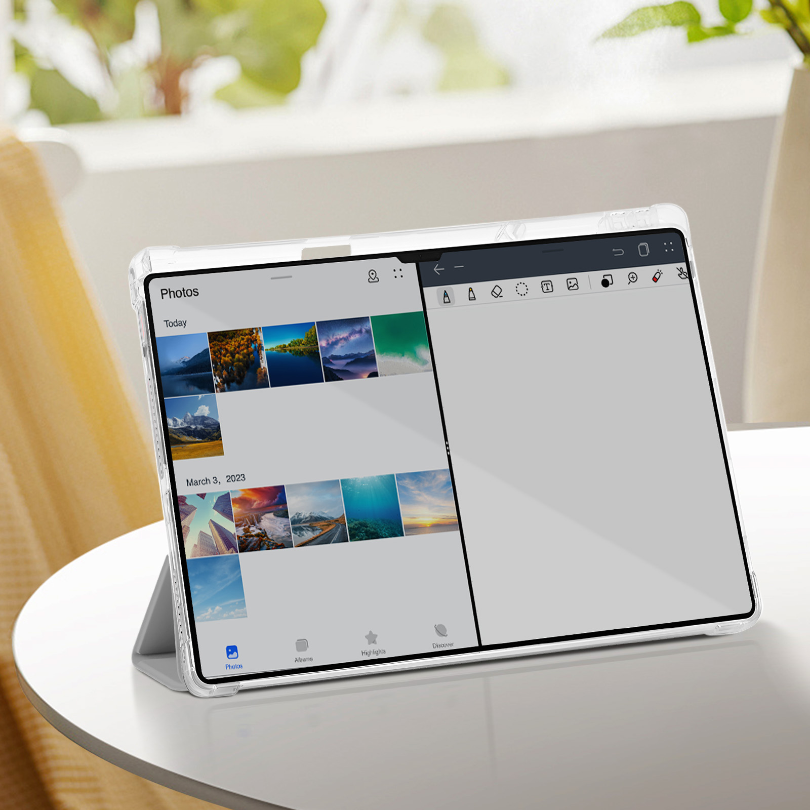 Tablet che mostra galleria fotografica con visualizzazione album su un tavolo bianco vicino a una finestra.
