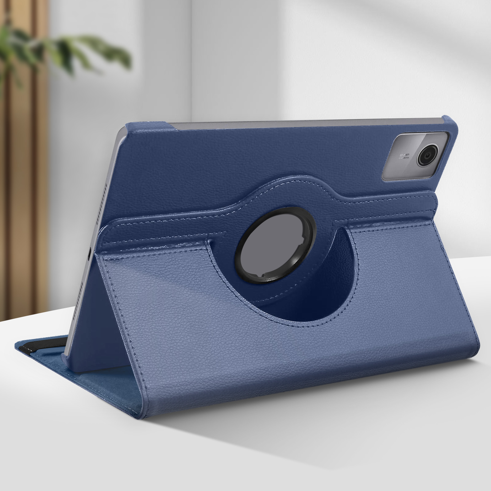 Un tablet blu scuro è in una custodia che può ruotare. La custodia è su una superficie bianca.
