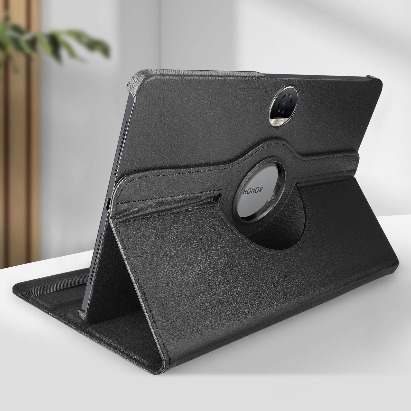 Una custodia nera per tablet con un tablet all'interno. La custodia è aperta e appoggiata su una superficie bianca.