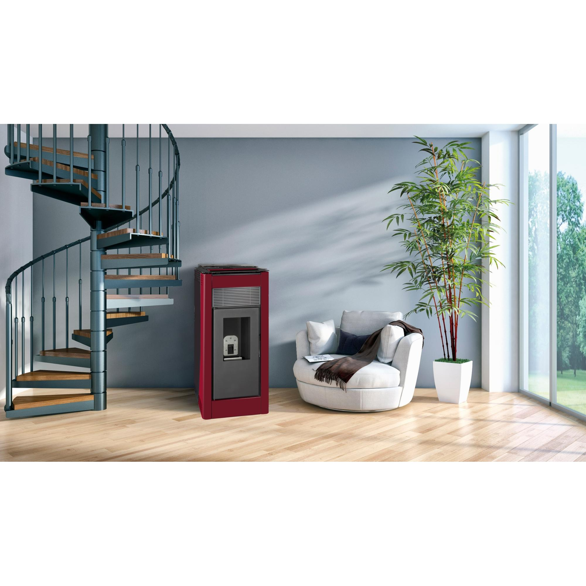 Estufa roja en una habitación con escalera de caracol y sillón blanco.