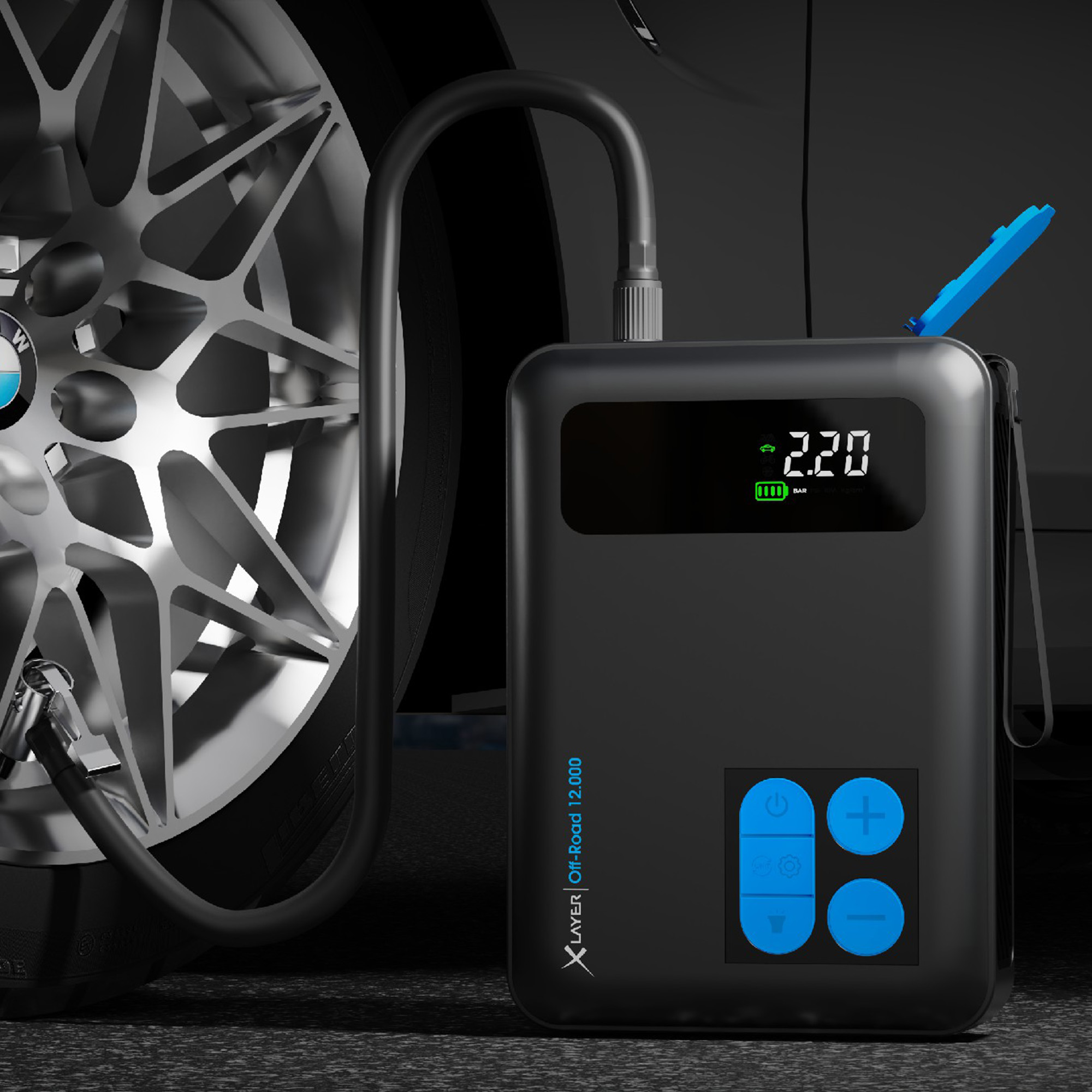 Schwarzer Autoreifenfüller mit digitaler Anzeige. Ein Autorad ist im Hintergrund.