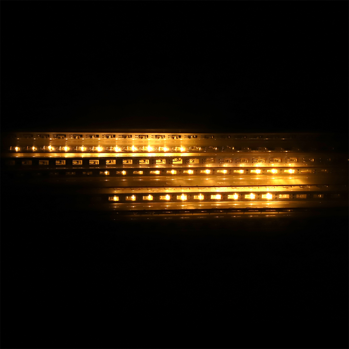 Horizontale Reihen gelber LEDs leuchten hell in einer dunklen Umgebung. Das Licht ist intensiv.