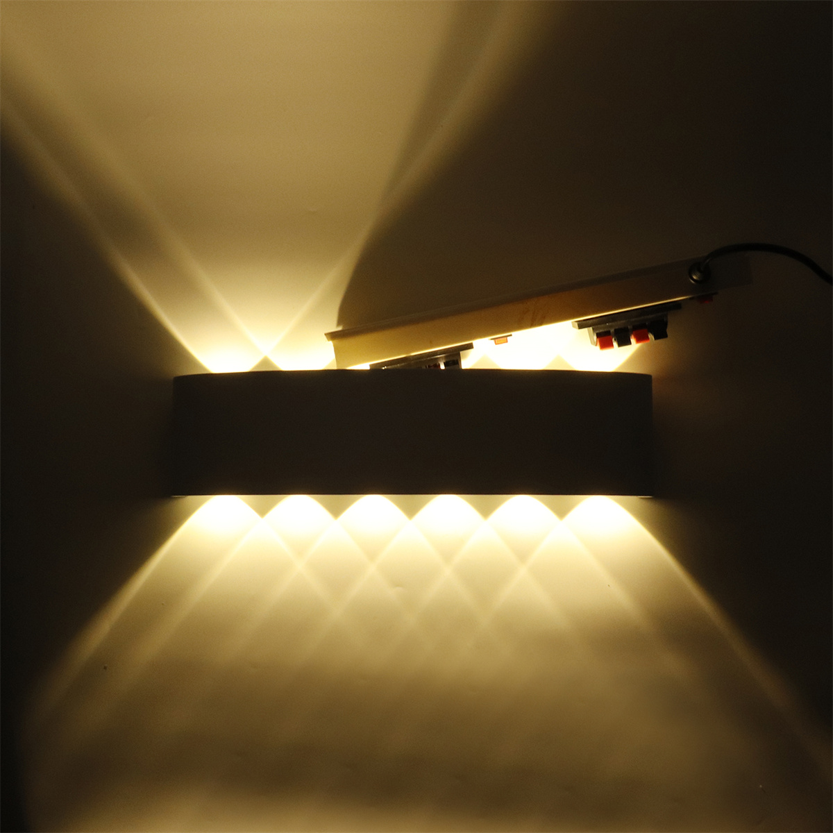 Wandleuchte mit mehreren Lichtstrahlen, die nach oben und unten gerichtet sind.