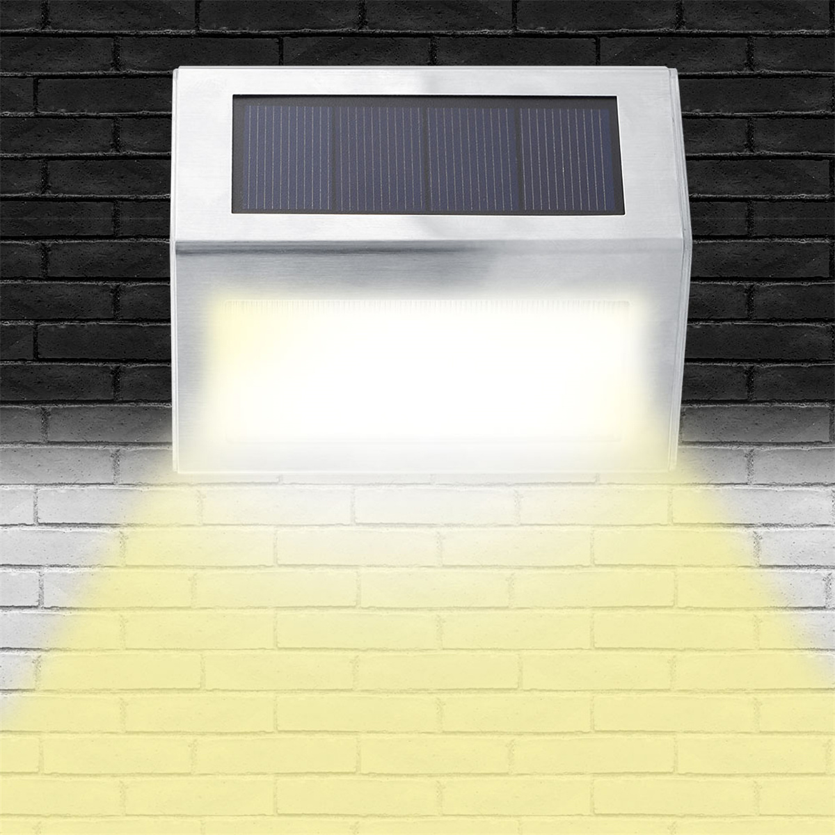 Eine solarbetriebene Leuchte an einer Ziegelmauer, die hellgelbes Licht nach unten abstrahlt.