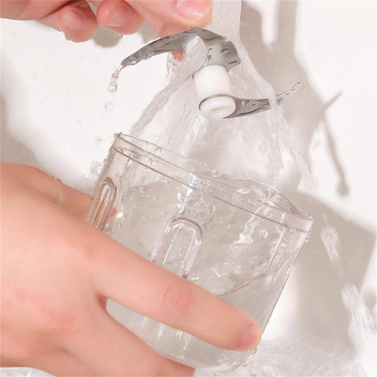 Wasser fließt über einen transparenten Plastikbehälter und eine Metallklinge.