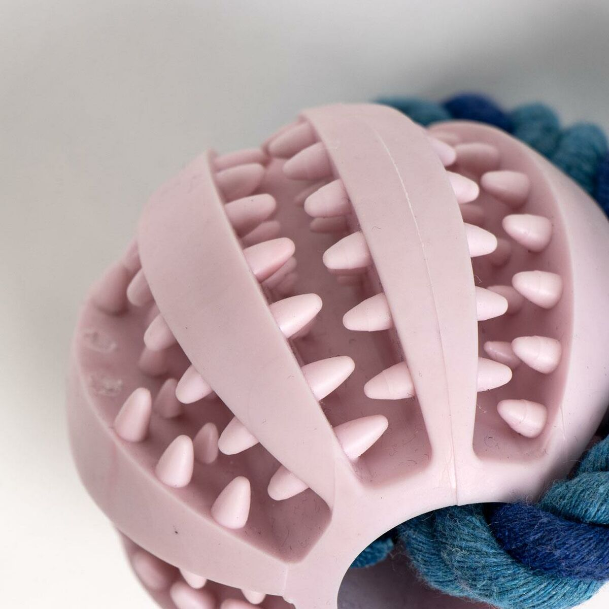 Giocattolo per cani rosa, forma a palla con punte, corda blu e verde acqua.