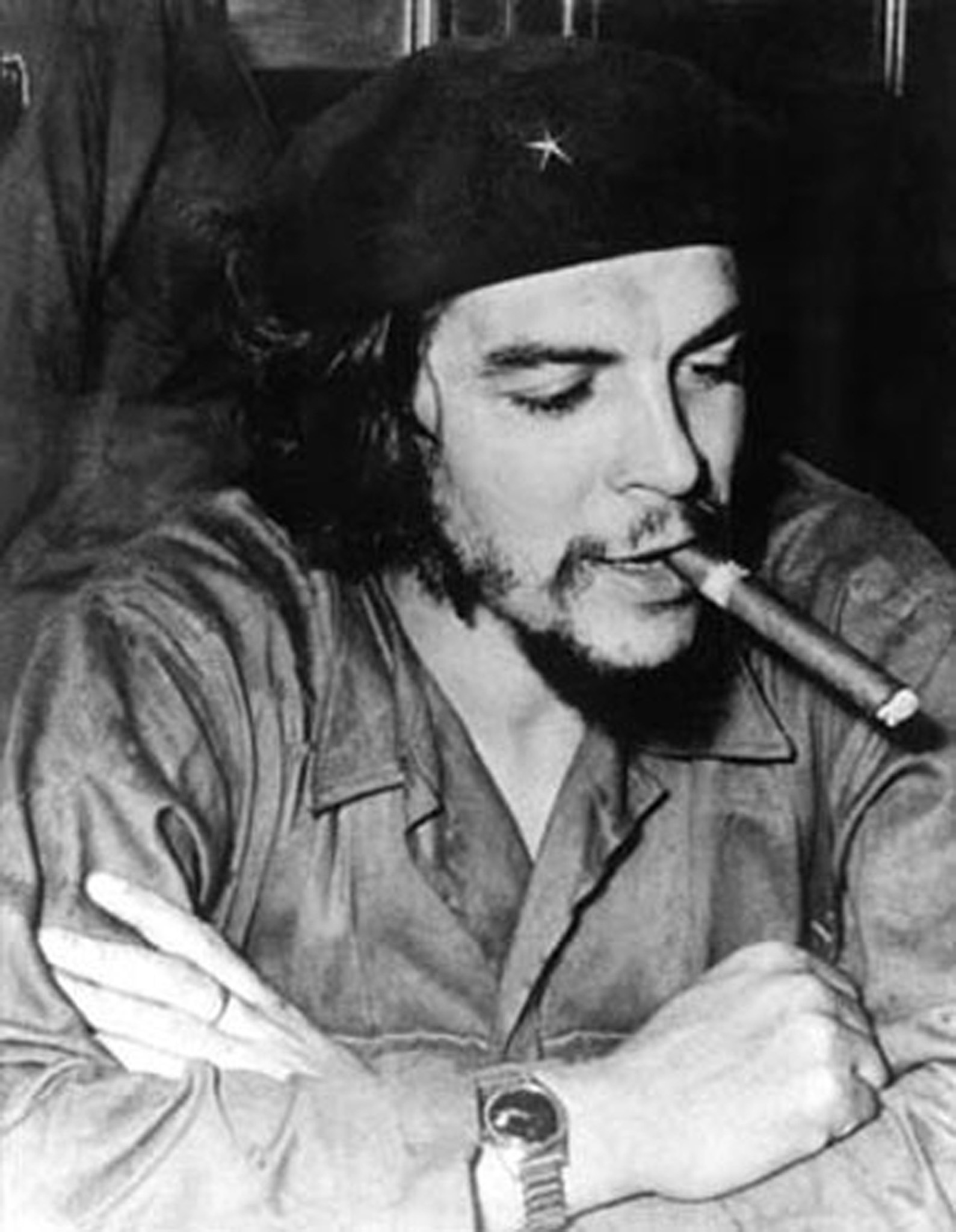 Schwarz-Weiß-Porträt von Che Guevara, der eine Zigarre raucht und eine Baskenmütze trägt.