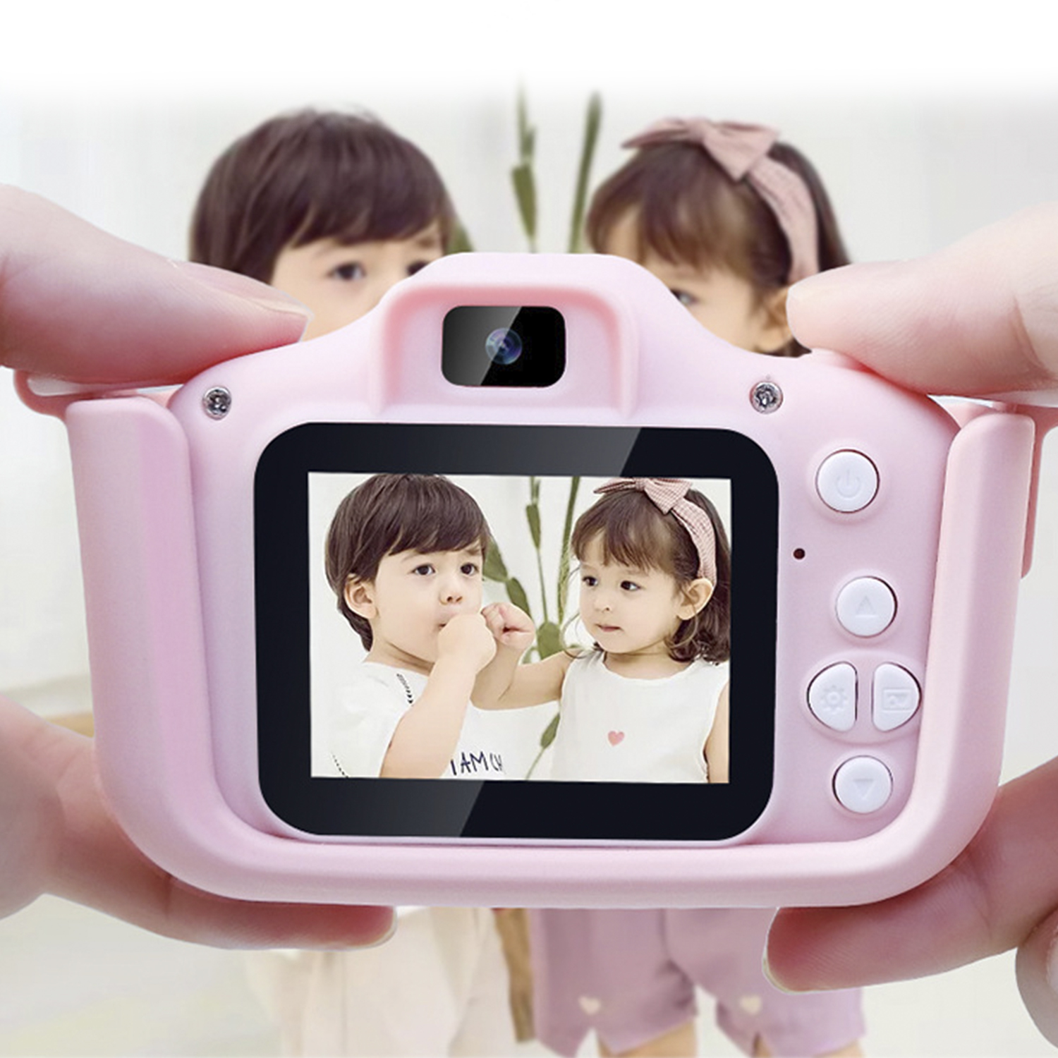 Eine rosa Kinderkamera zeigt die Gesichter zweier Kinder. Die Kamera wird von Händen gehalten.