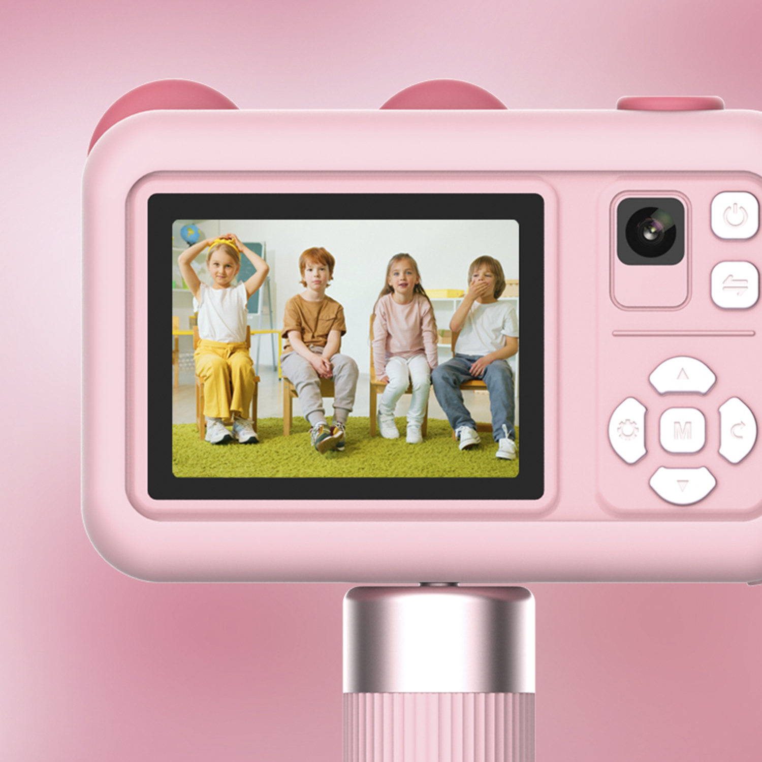Fotocamera giocattolo rosa che mostra quattro bambini in una stanza, che tengono un bastone per selfie.