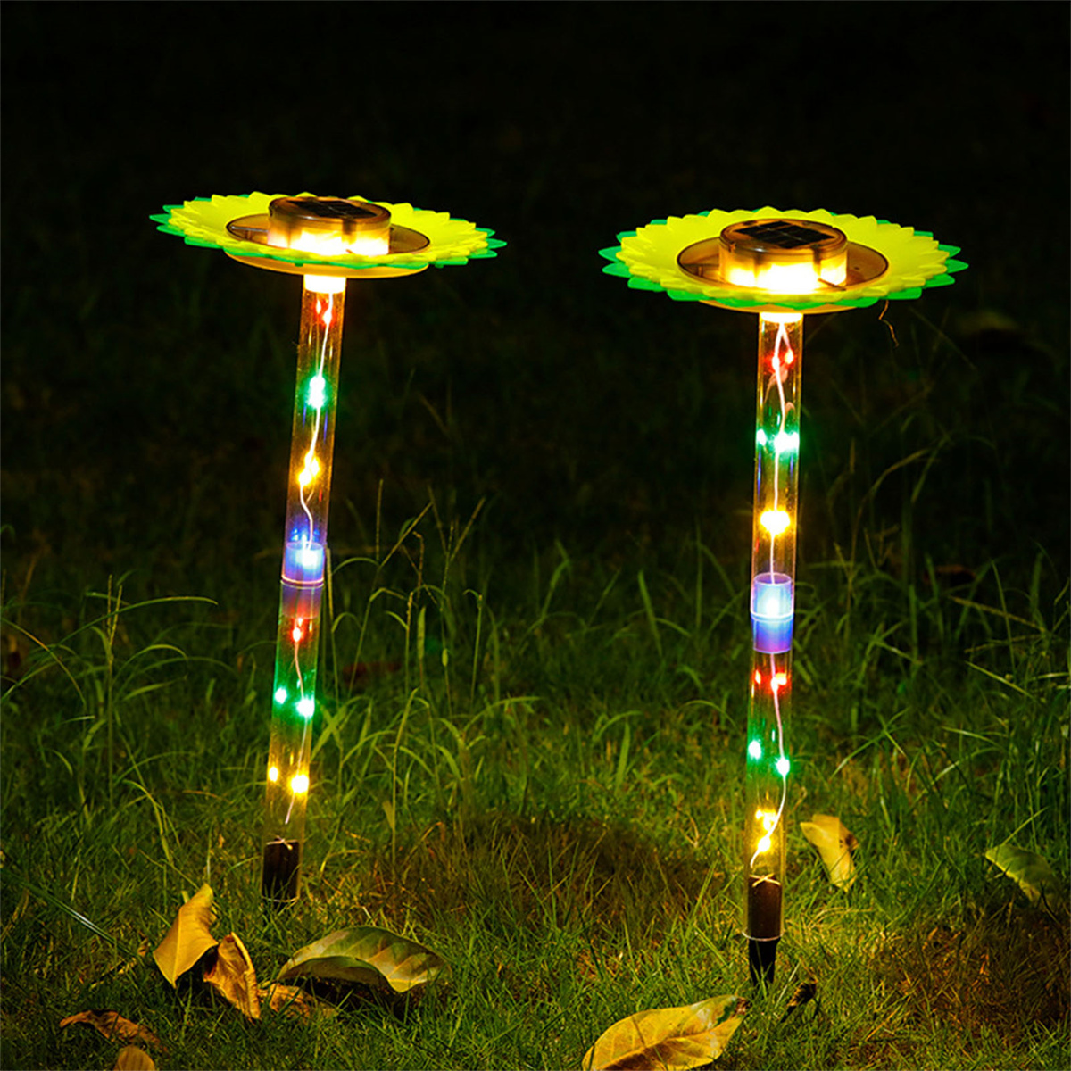 Zwei solarbetriebene Gartenleuchten mit sonnenblumenförmigen Aufsätzen und mehrfarbigen LEDs.