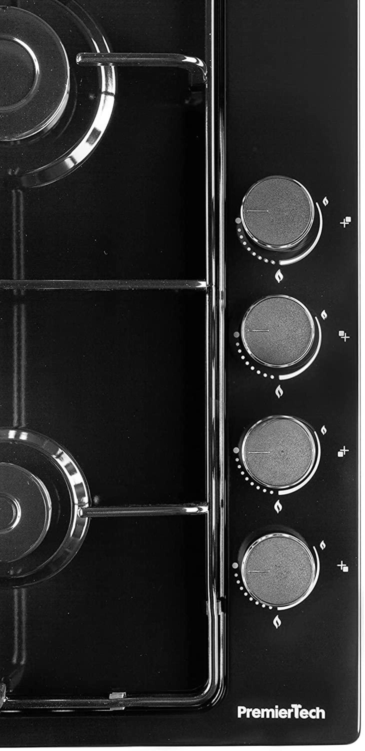 Piano cottura in vetro nero con quattro bruciatori e manopole di controllo. Lo sfondo è bianco.