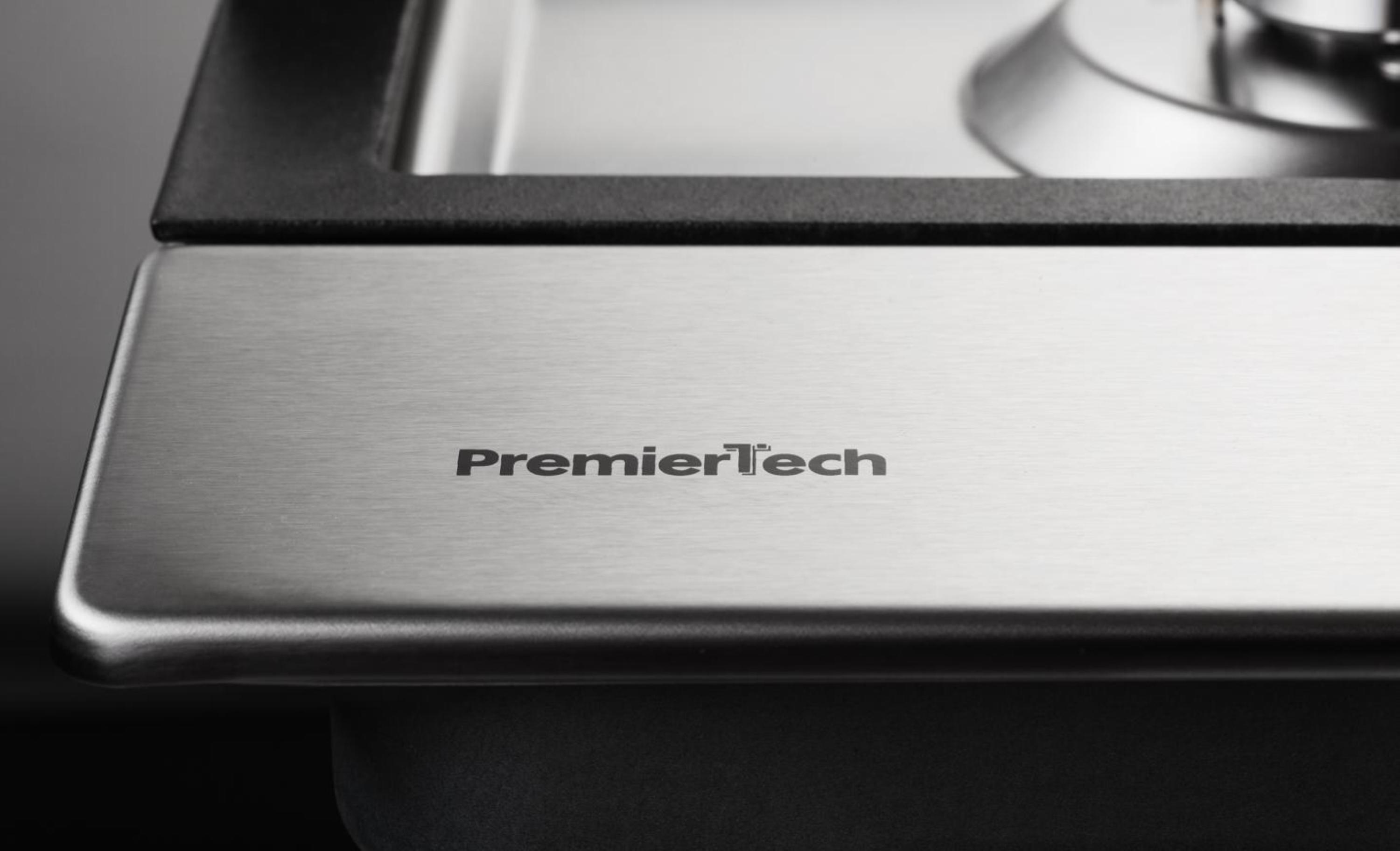 Logo PremierTech su una superficie in metallo spazzolato.