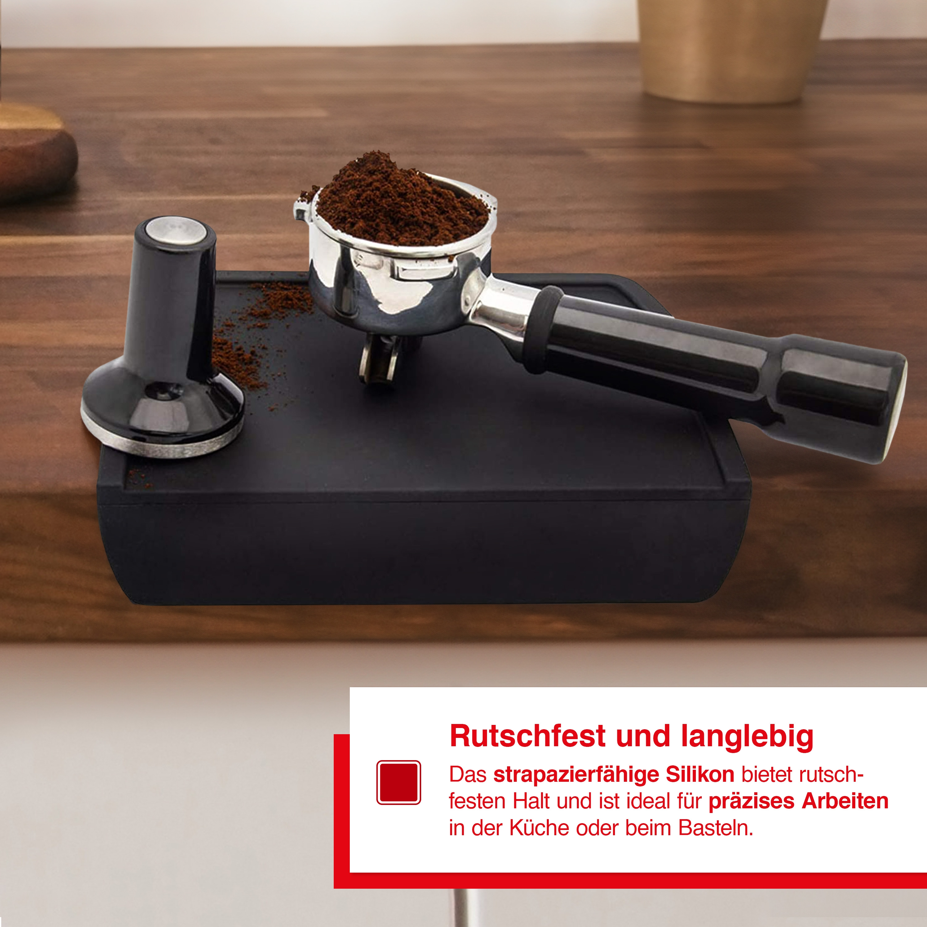 Schwarzer Kaffeestampfer und -halter. Der Tamper presst Kaffeepulver in einen Siebträger auf einer schwarzen Matte.