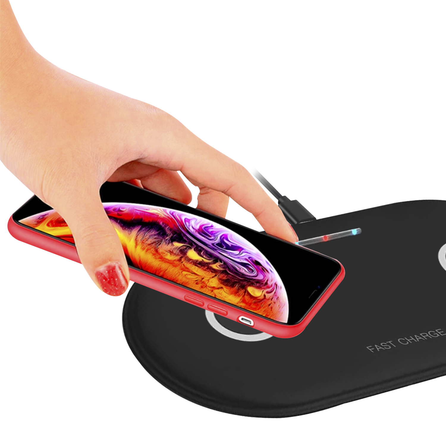 Mano che posiziona un telefono rosso su un caricatore wireless nero con un telefono.