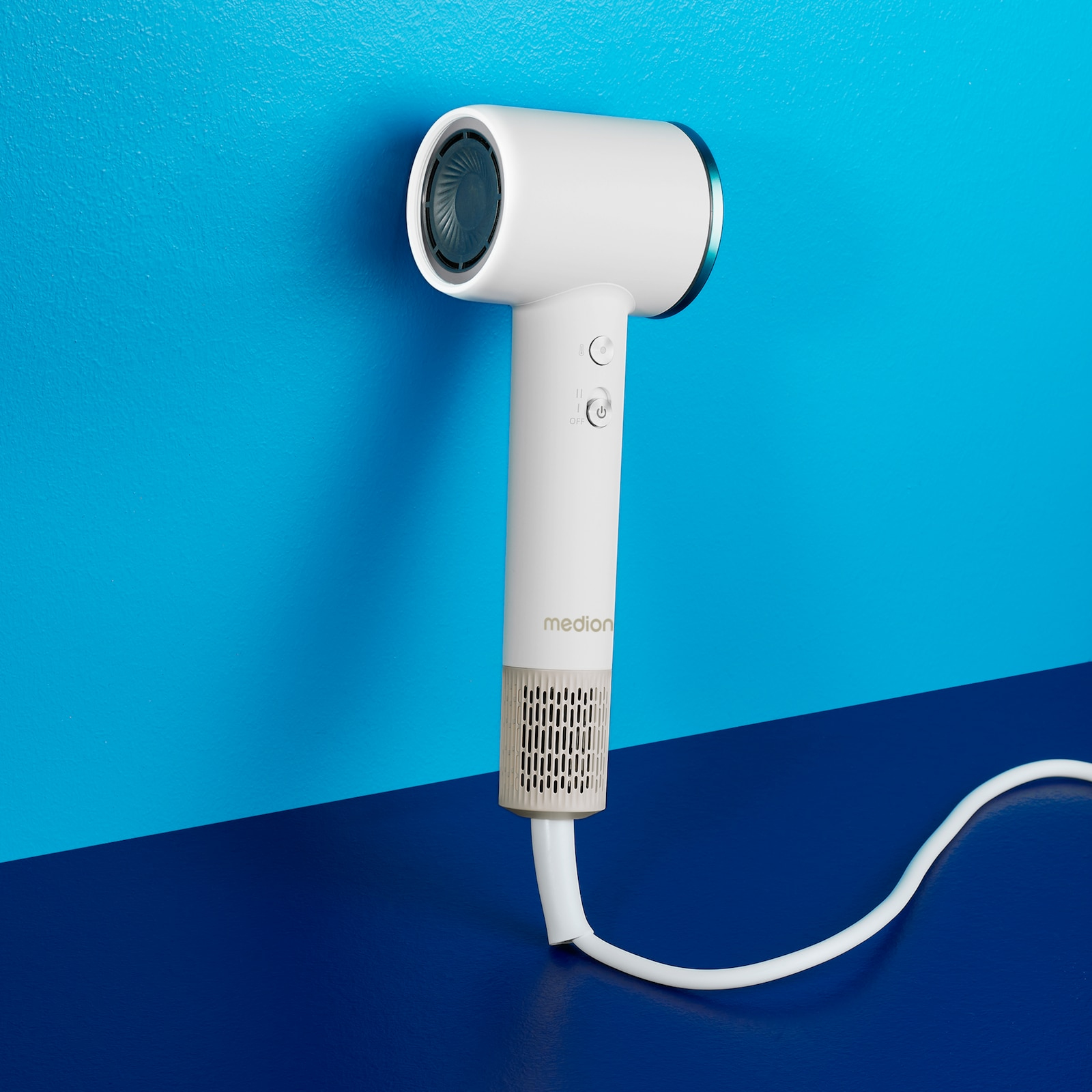 Biała i niebieska suszarka do włosów. Ma biały uchwyt i niebiesko-szary wlot powietrza.