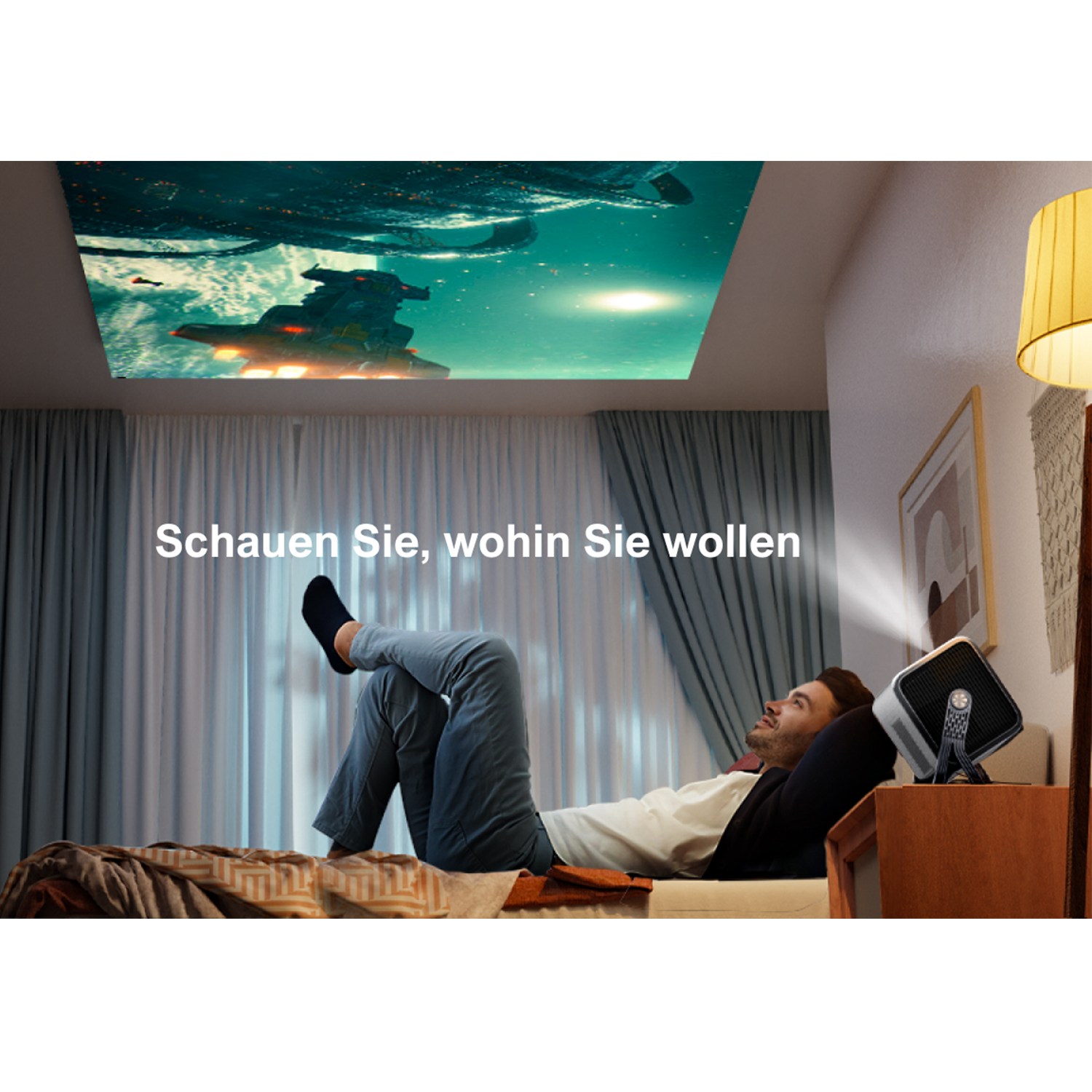 Ein Mann liegt auf einem Bett und betrachtet ein projiziertes Bild an der Decke. Ein Projektor steht auf einem Tisch.