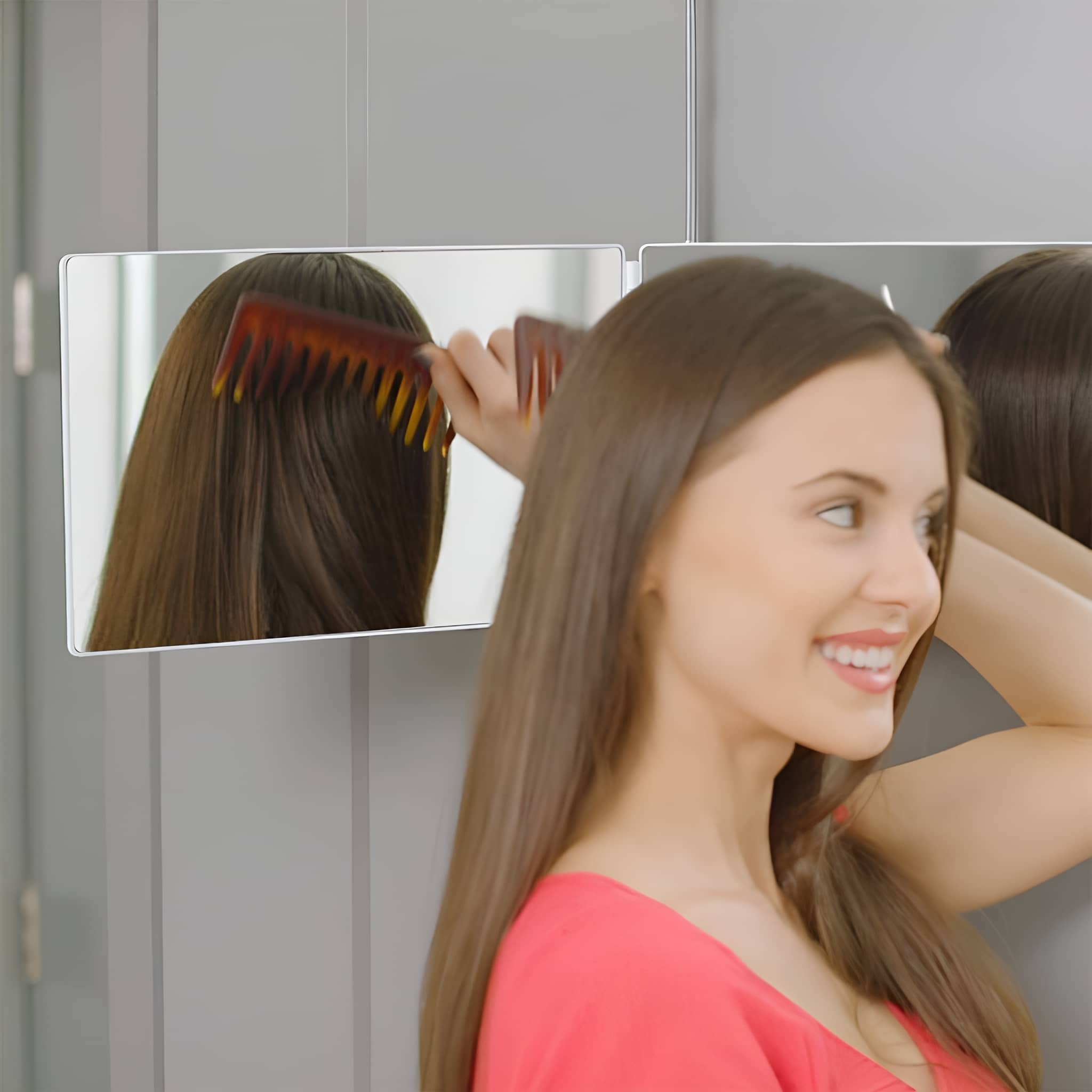 Eine Frau kämmt ihre langen, braunen Haare vor einem Spiegel.