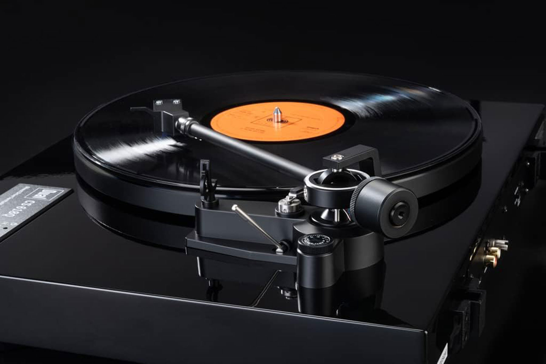 Ein schwarzer Plattenspieler mit einer Vinylplatte, die darauf abgespielt wird.